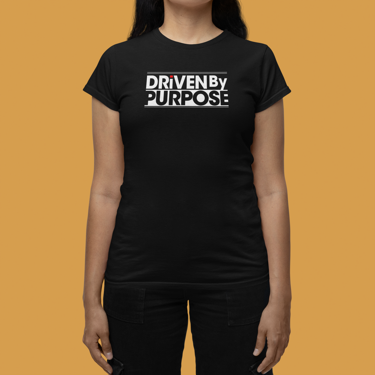 Driven by Purpose Women's T-Shirt in black, woman modeling it against an orange backdrop, motivational gift