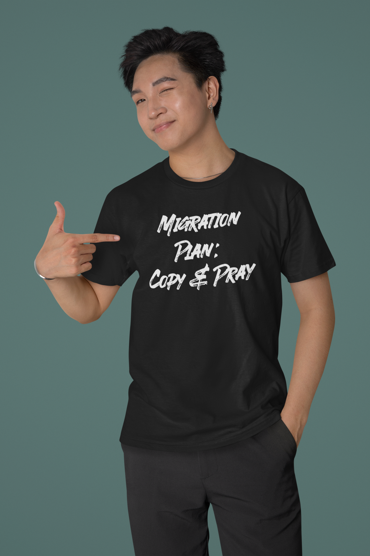 'Migration Plan: Copy and Pray' t-shirt in black, man pointing to the print, funny gift for developers