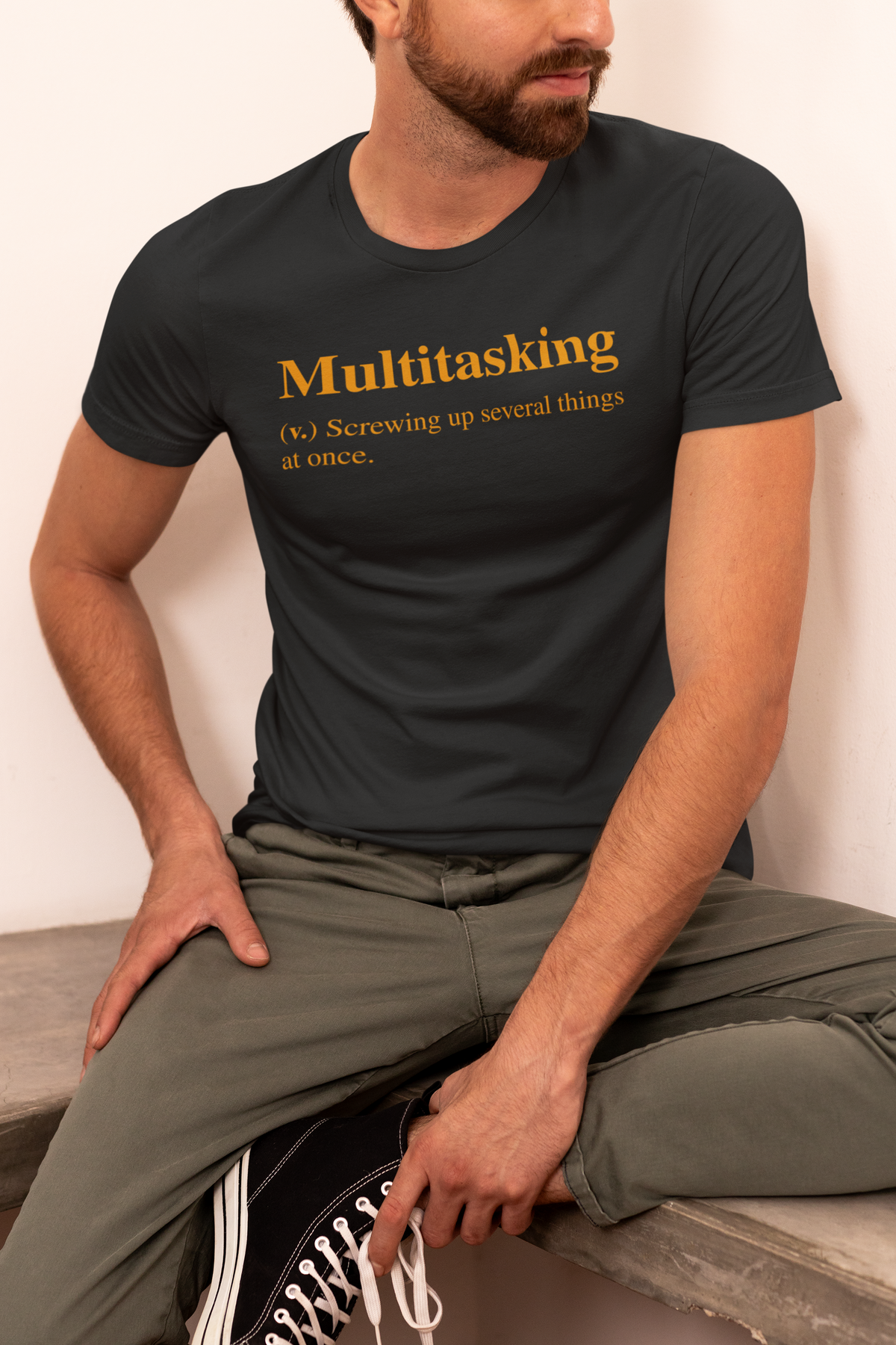 Multitasking t-shirt in black, man sitting cross legged wearing it, funny procrastinator gift for coworkers