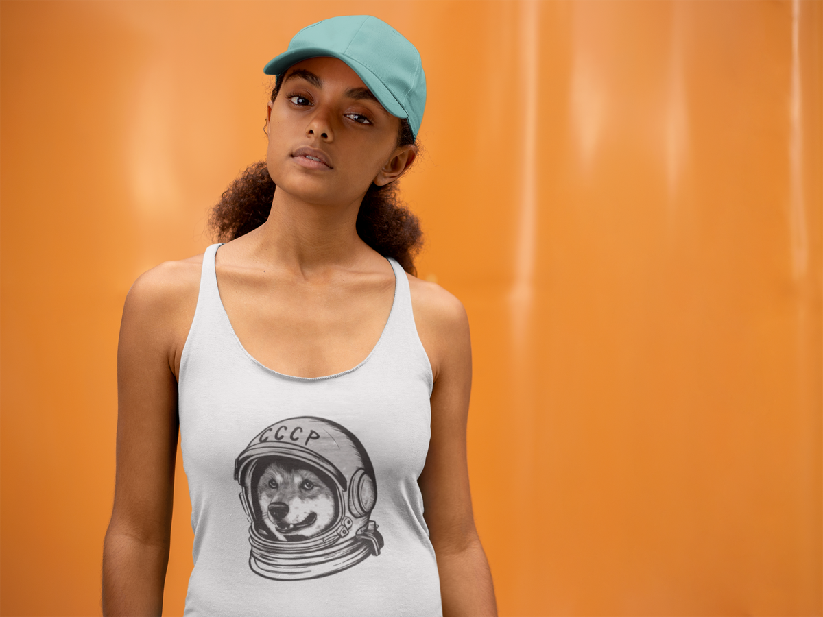 'CCCP Astronaut Dog' racerback tank top in white, woman wearing it by an orange wall, Tank Top mockup, Geekpsters