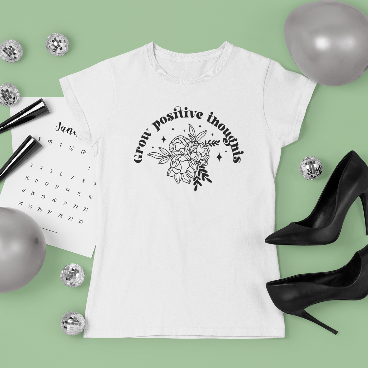 'Grow Positive Thoughts' t-shirt in white, flat lay lifestyle setting
