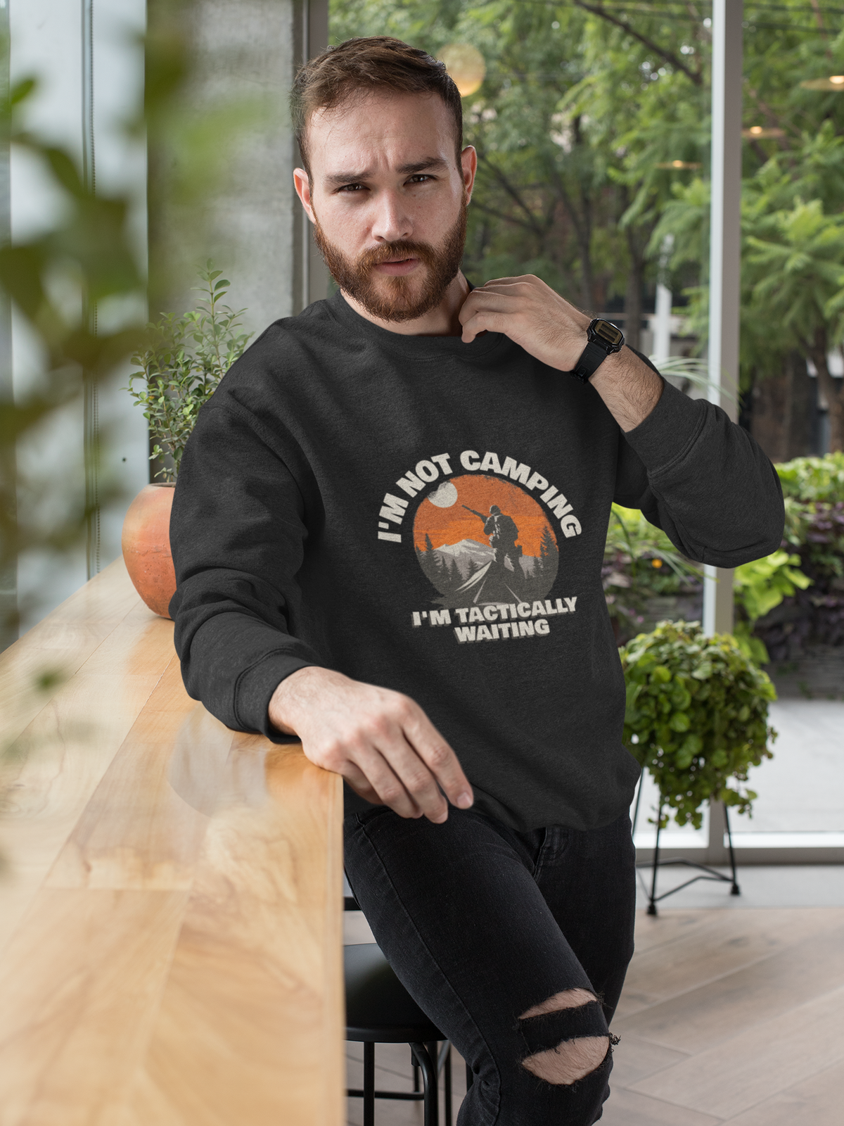 'I'm Not Camping' hiker graphic sweatshirt in black, bearded man wearing it outdoors, funny gift