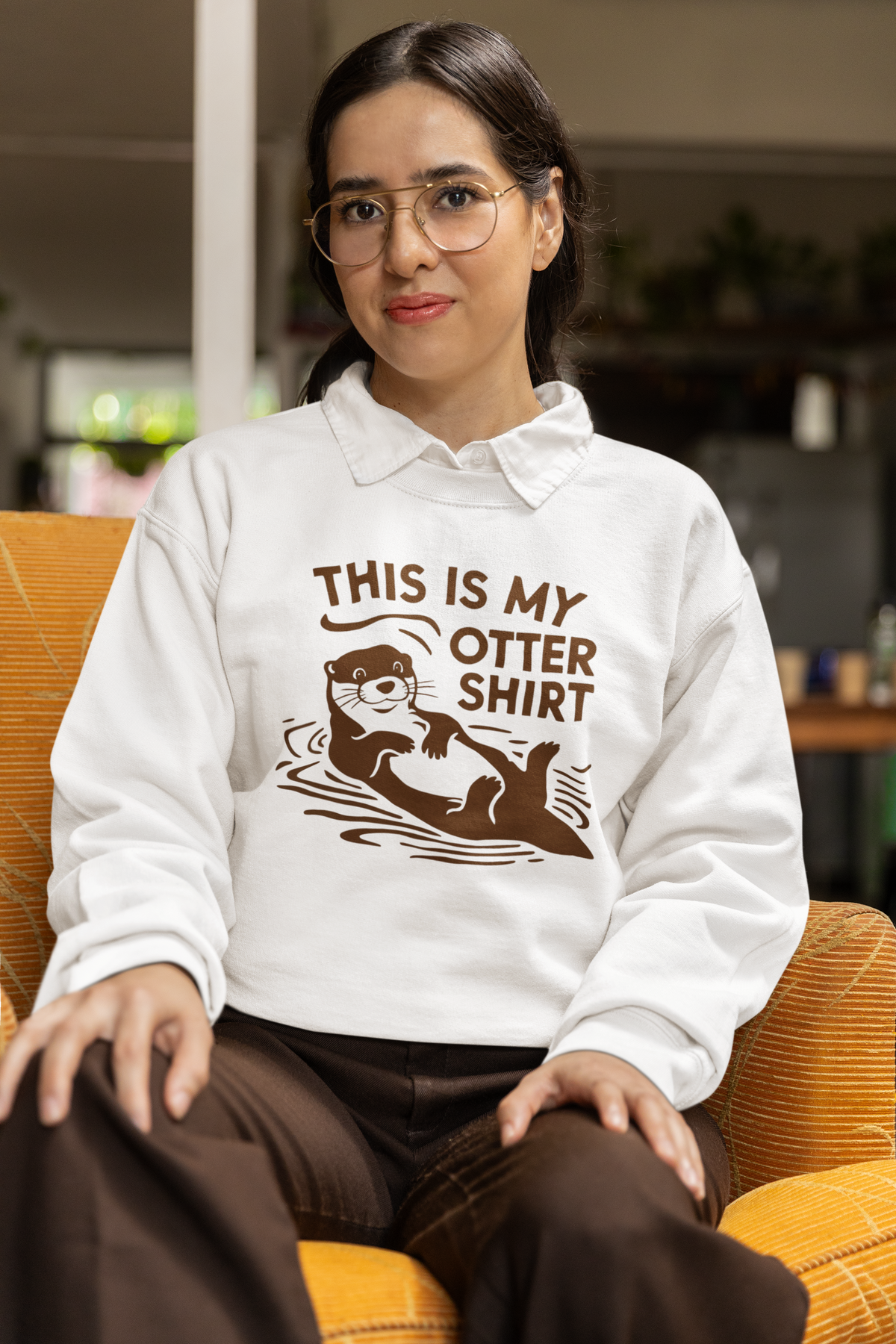'This Is My Otter Shirt' sweatshirt in white, woman wearing it seated indoors, funny gift idea