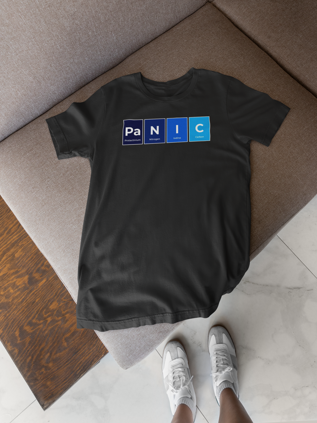 'Pa-N-I-C' periodic table t-shirt in black, flat lay folded on a wooden tray, funny chemistry gift