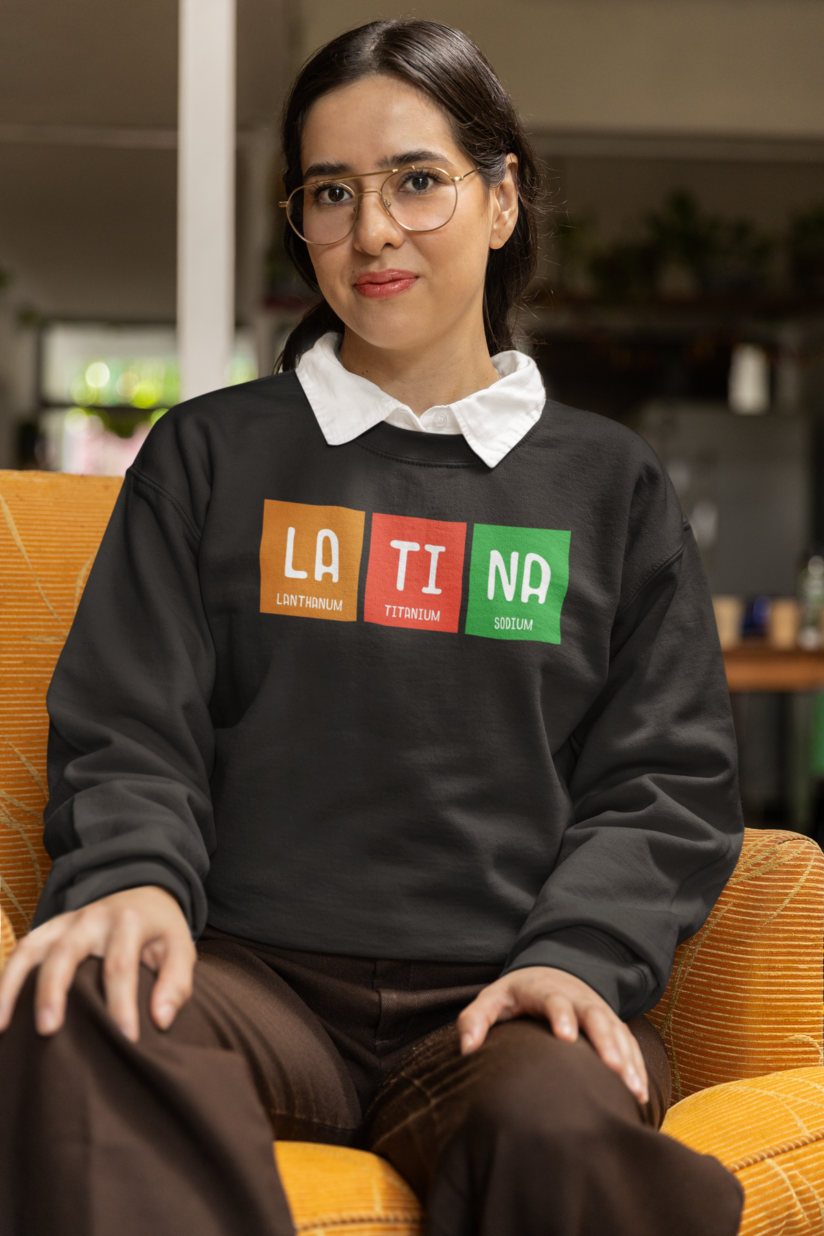 LA-TI-NA periodic table sweatshirt in black, woman wearing it seated indoors, funny gift idea
