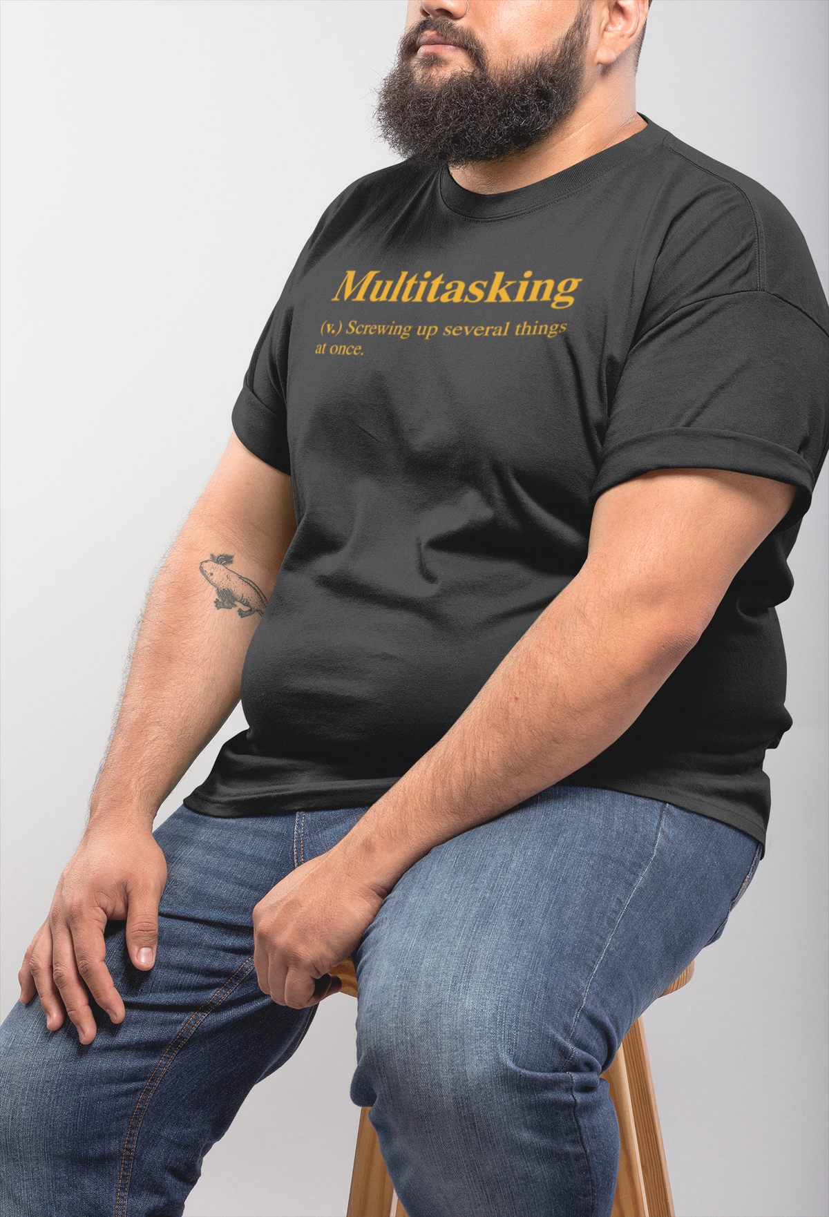 Multitasking definition tee in black, man sitting outdoors wearing it, funny sarcastic office humor shirt