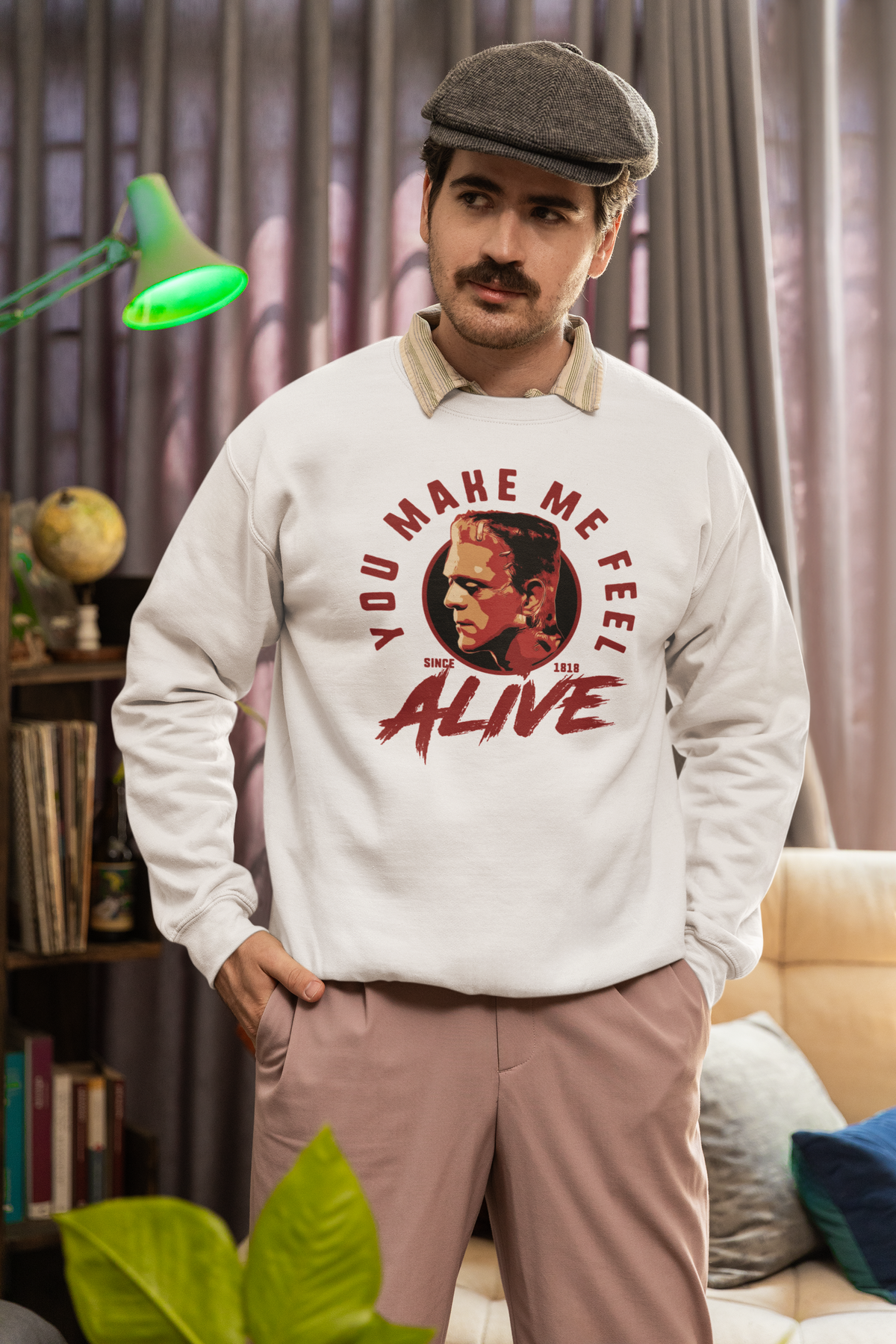 "You Make Me Feel Alive" portrait sweatshirt in white, man in a flat cap wearing it indoors, fan gift for him