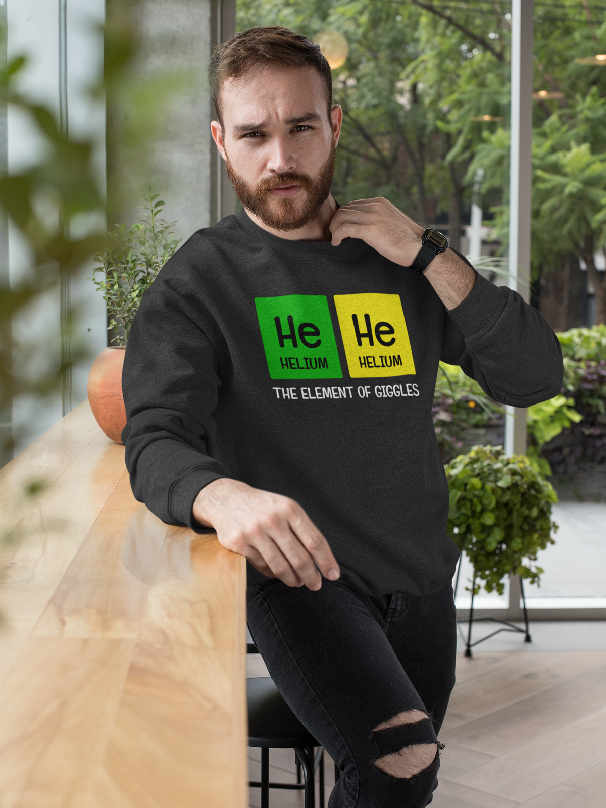 'He-He: The Element of Giggles' sweatshirt in black, bearded man wearing it, funny science gift