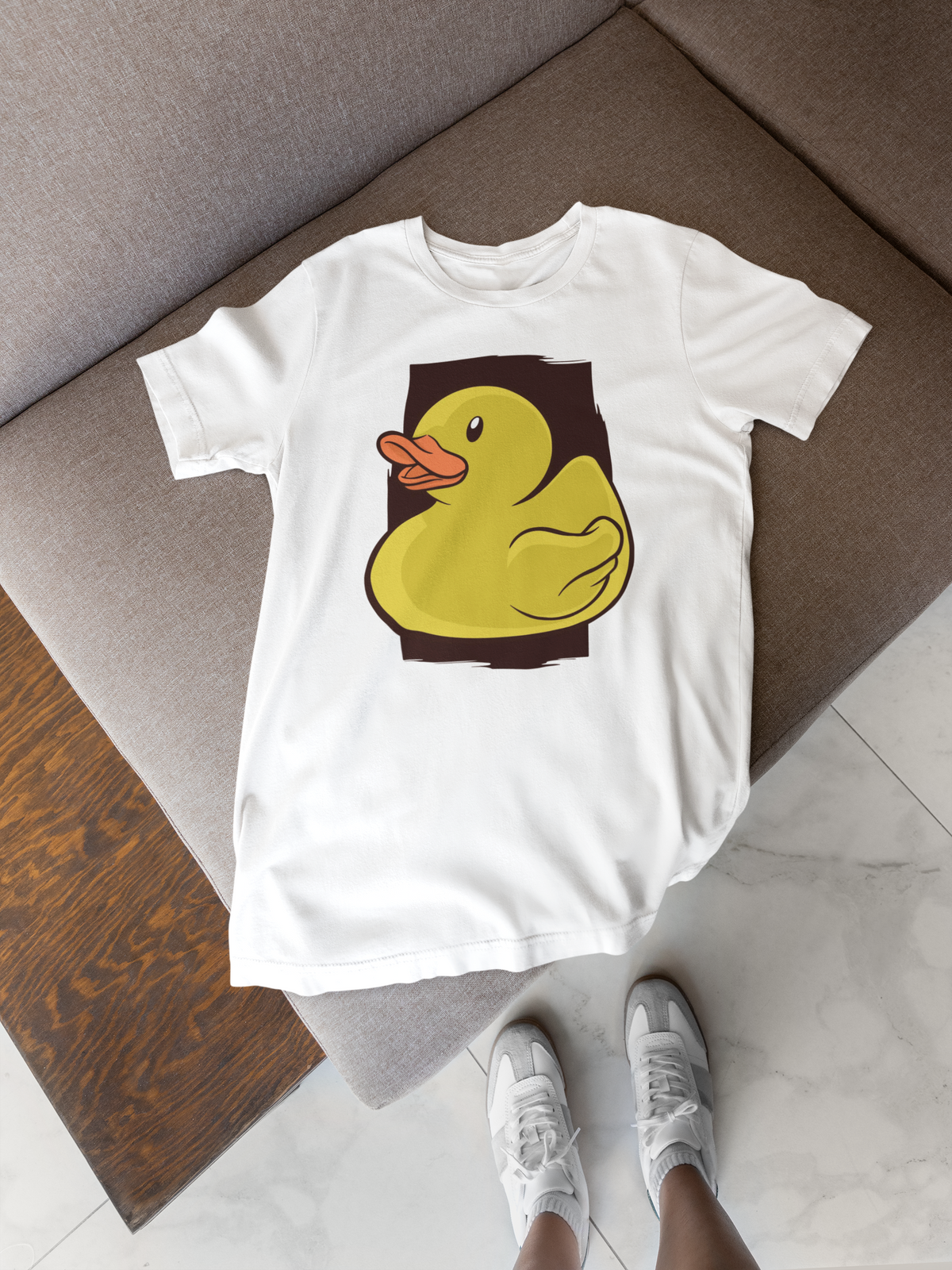 Classic rubber duck t-shirt in white, flat lay on a wooden floor with sneakers, funny quirky gift shirt