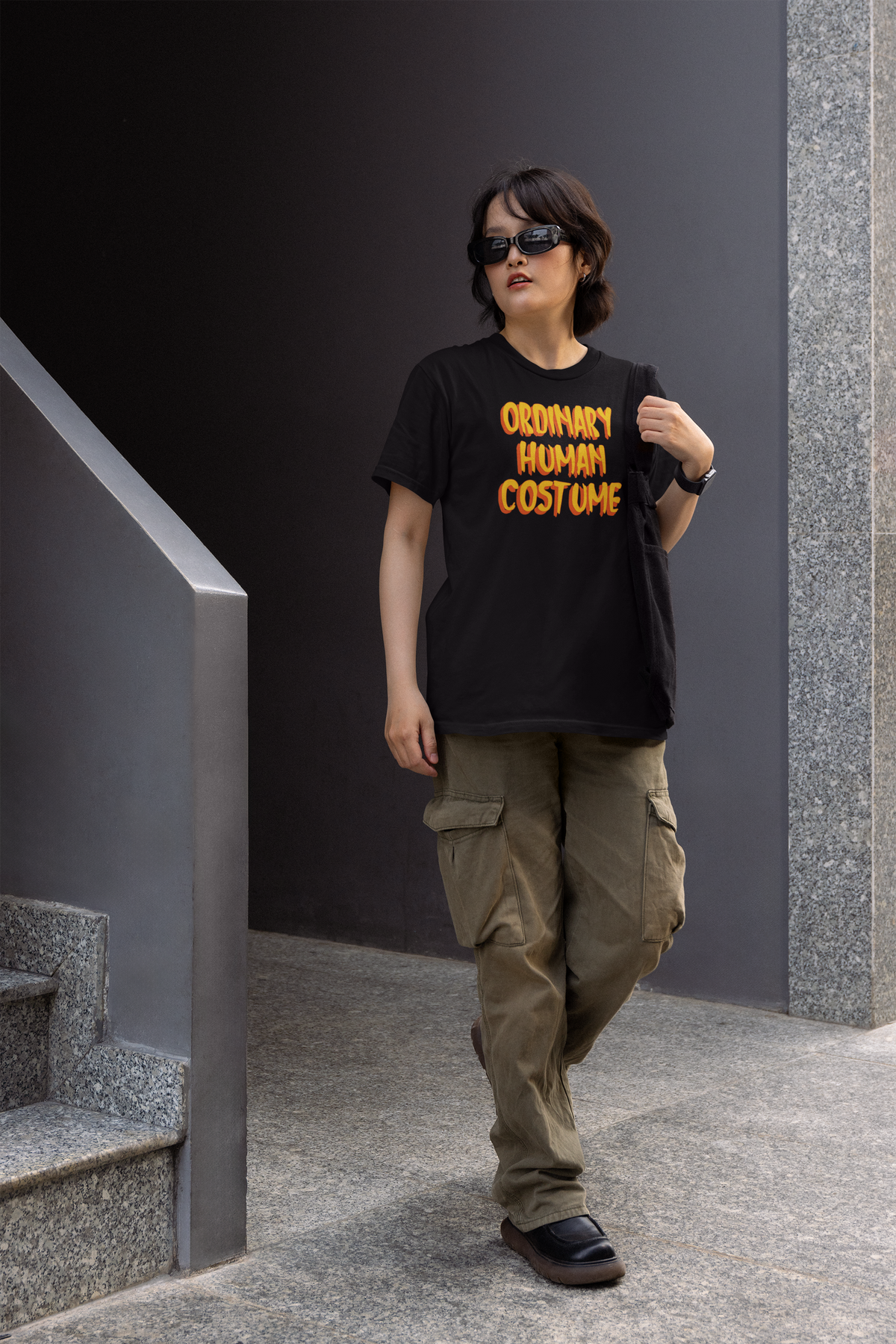 'Ordinary Human Costume' funny halloween t-shirt in black, woman walking outdoors wearing it, funny gift