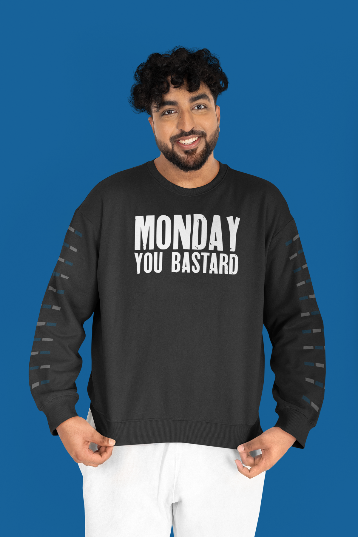 'Monday You Bastard' text sweatshirt in black with sleeve print, man standing against blue backdrop, gift