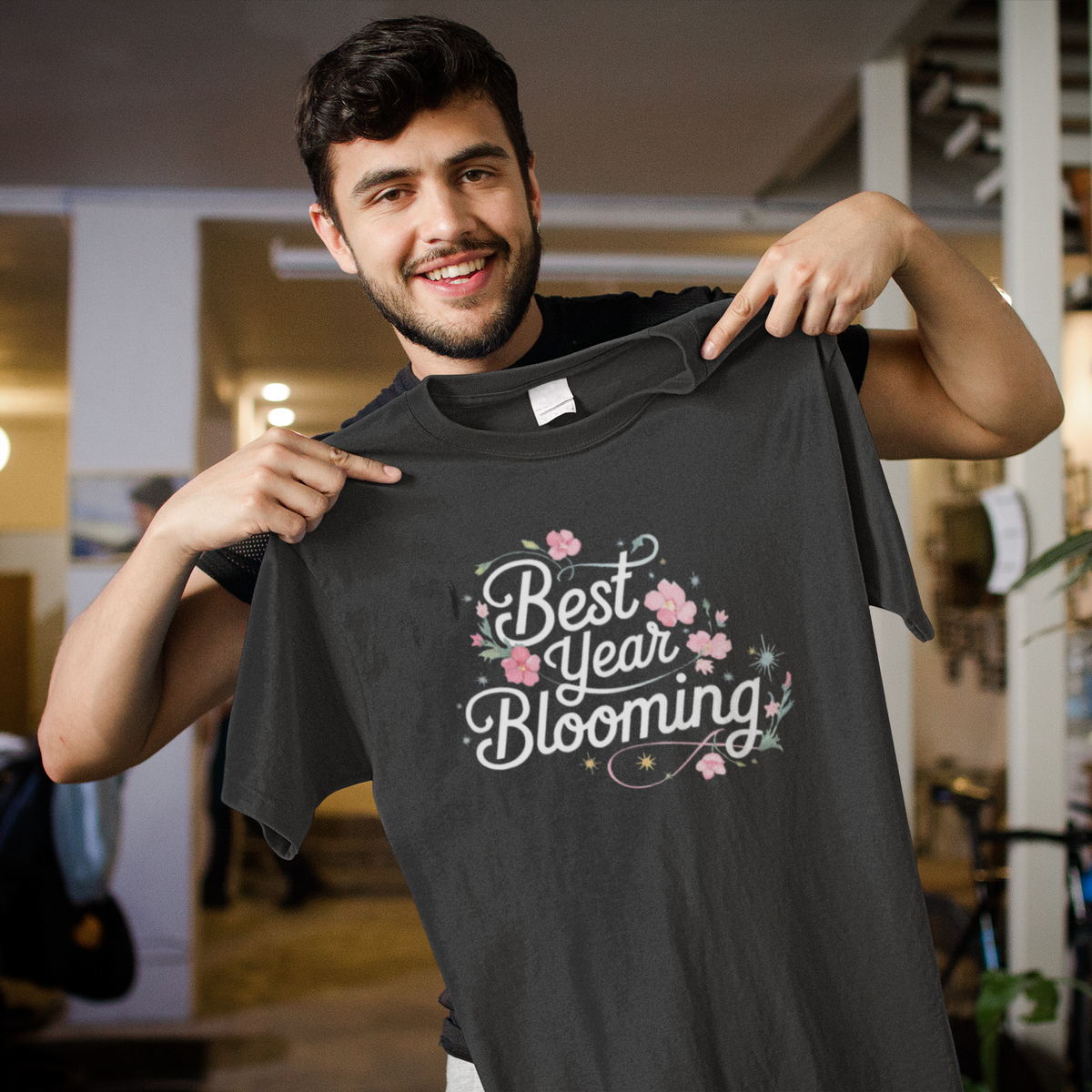 Best Year Blooming black t-shirt held up by a smiling man indoors, funny floral gift idea