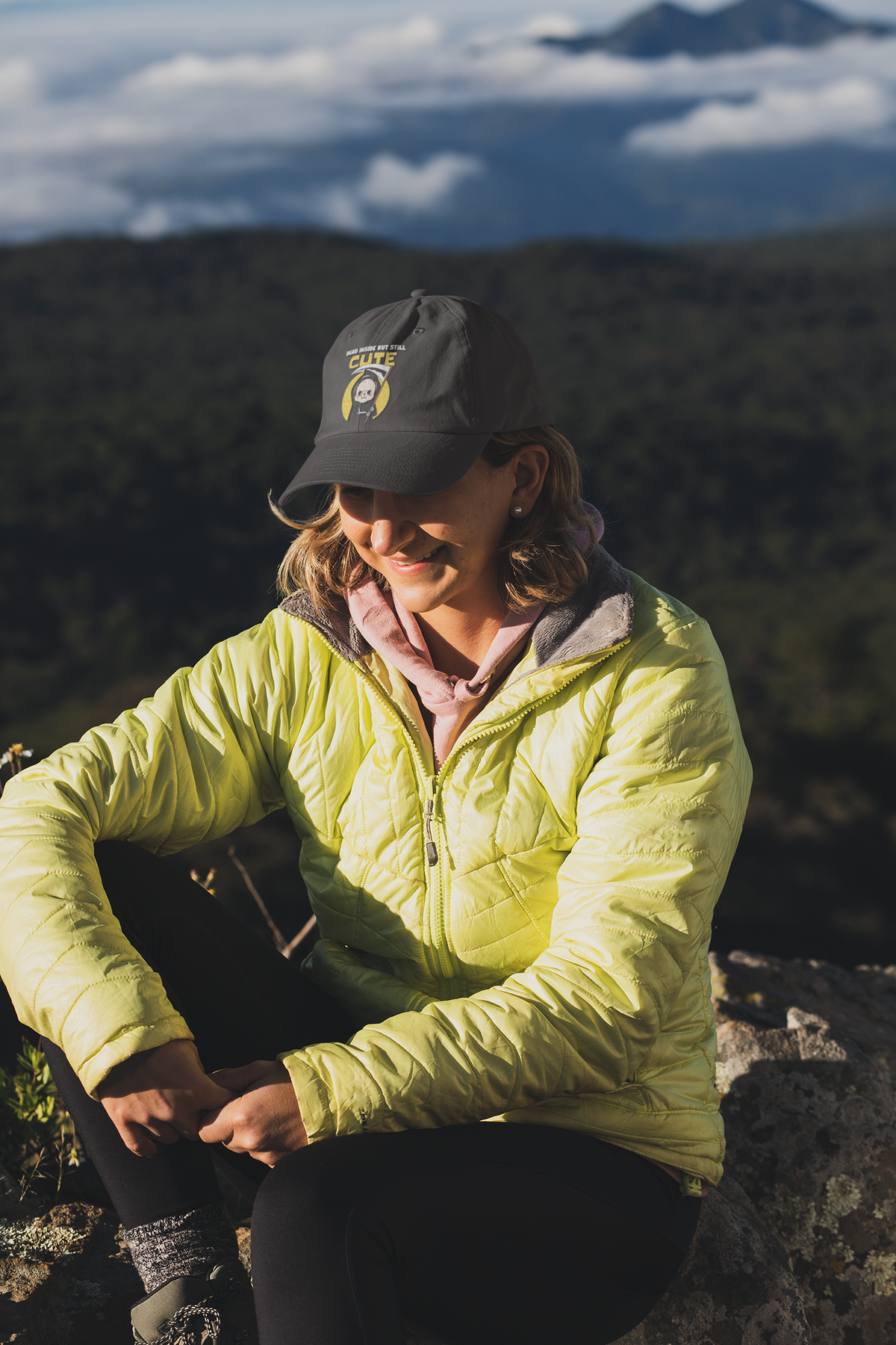 Dead Inside but Still Cute embroidered dad hat worn by a woman on a mountain hike, lifestyle mockup, Geekpsters