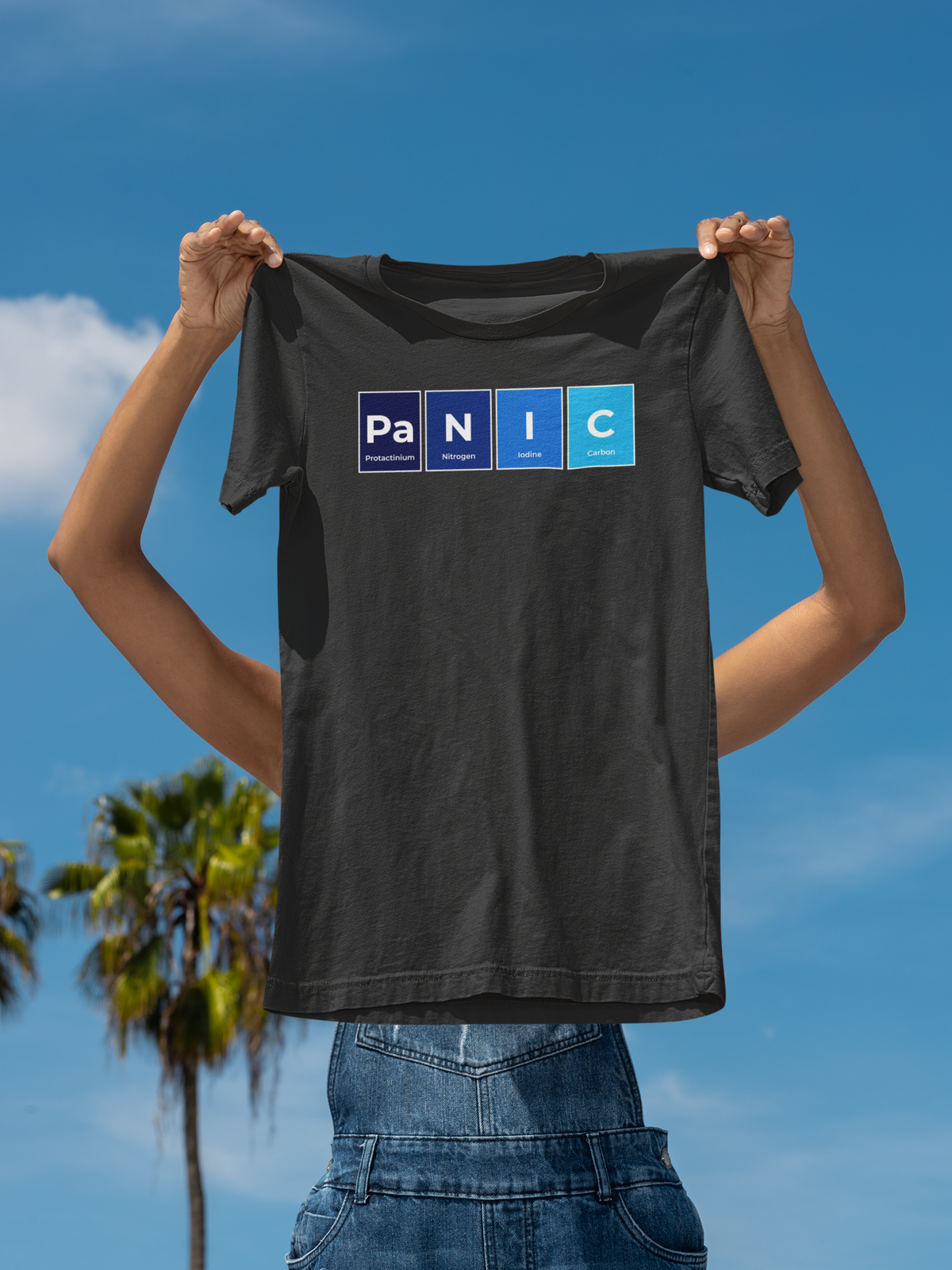 'Pa-N-I-C' periodic table t-shirt in black, woman holding it up outdoors, funny science pun tee