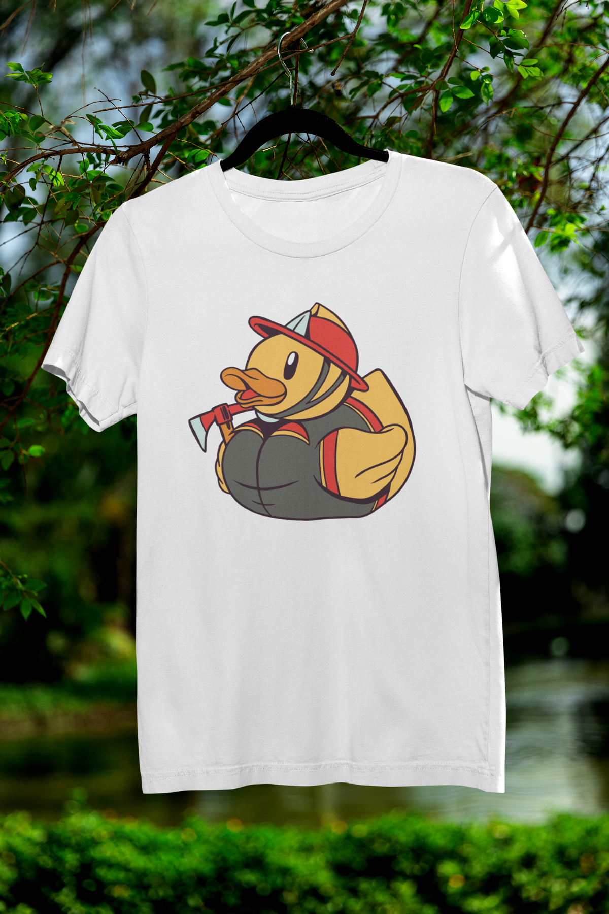Firefighter duck t-shirt in white, hanging outdoors among green trees, funny gift for firefighters