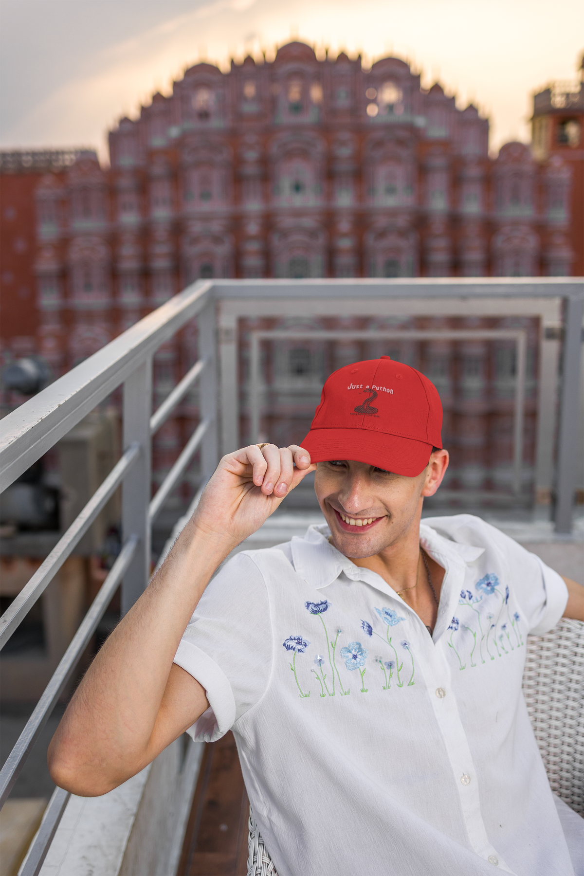 Just a Python embroidered dad hat worn by a man on a city balcony, lifestyle mockup, Geekpsters
