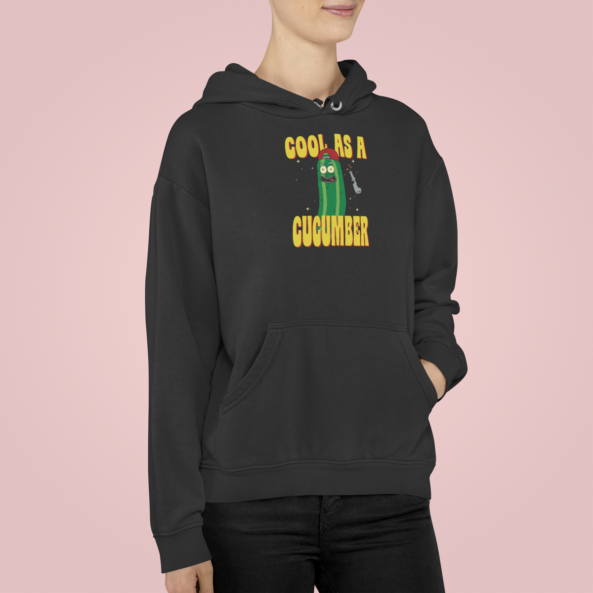 "Cool As A Cucumber" cartoon graphic hoodie in black, woman wearing it on pink backdrop, funny gift for her