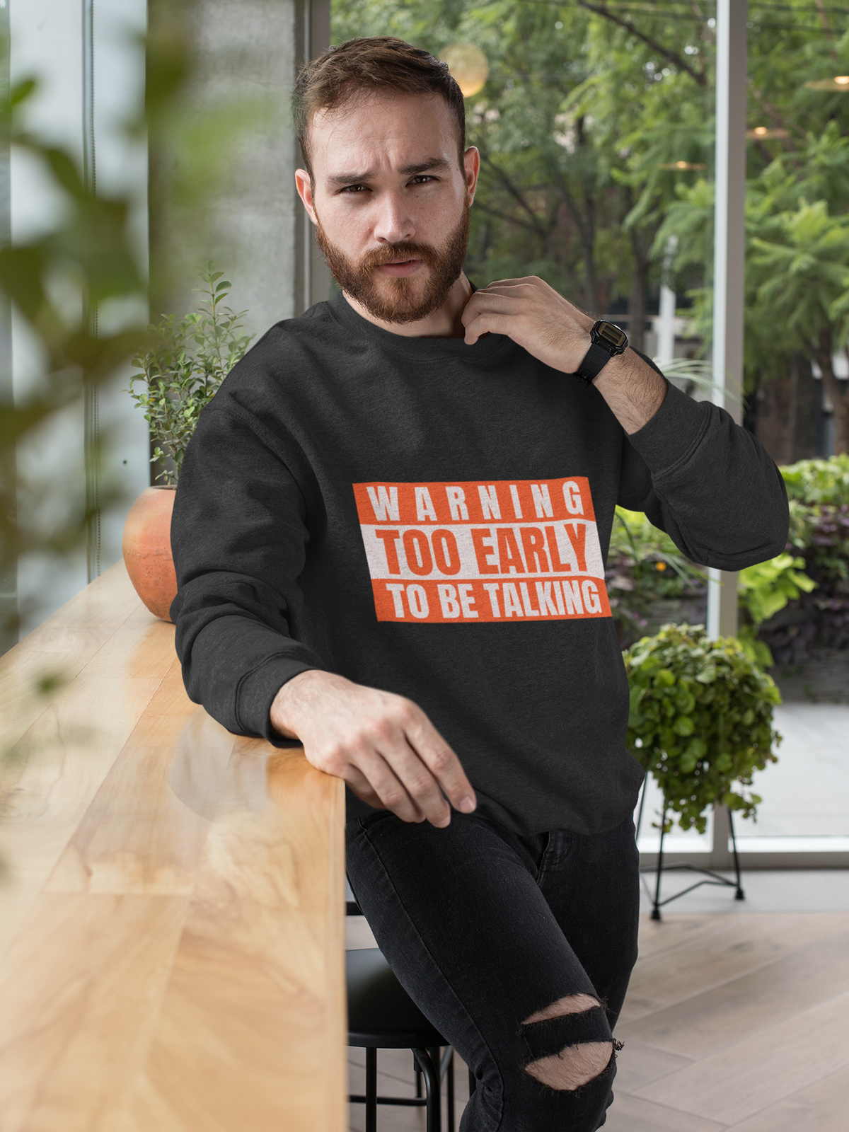 'Warning Too Early To Be Talking' sweatshirt in black, bearded man sitting indoors, funny sarcastic gift
