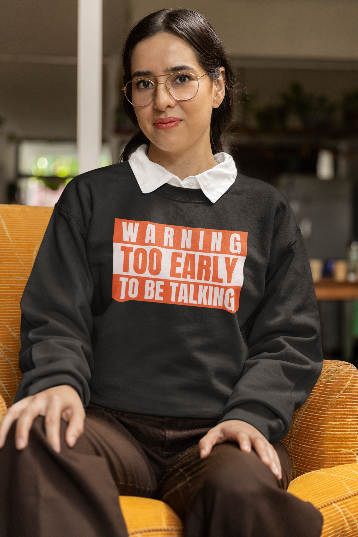 'Warning Too Early To Be Talking' sweatshirt in black, smiling woman sitting indoors, funny sarcastic gift