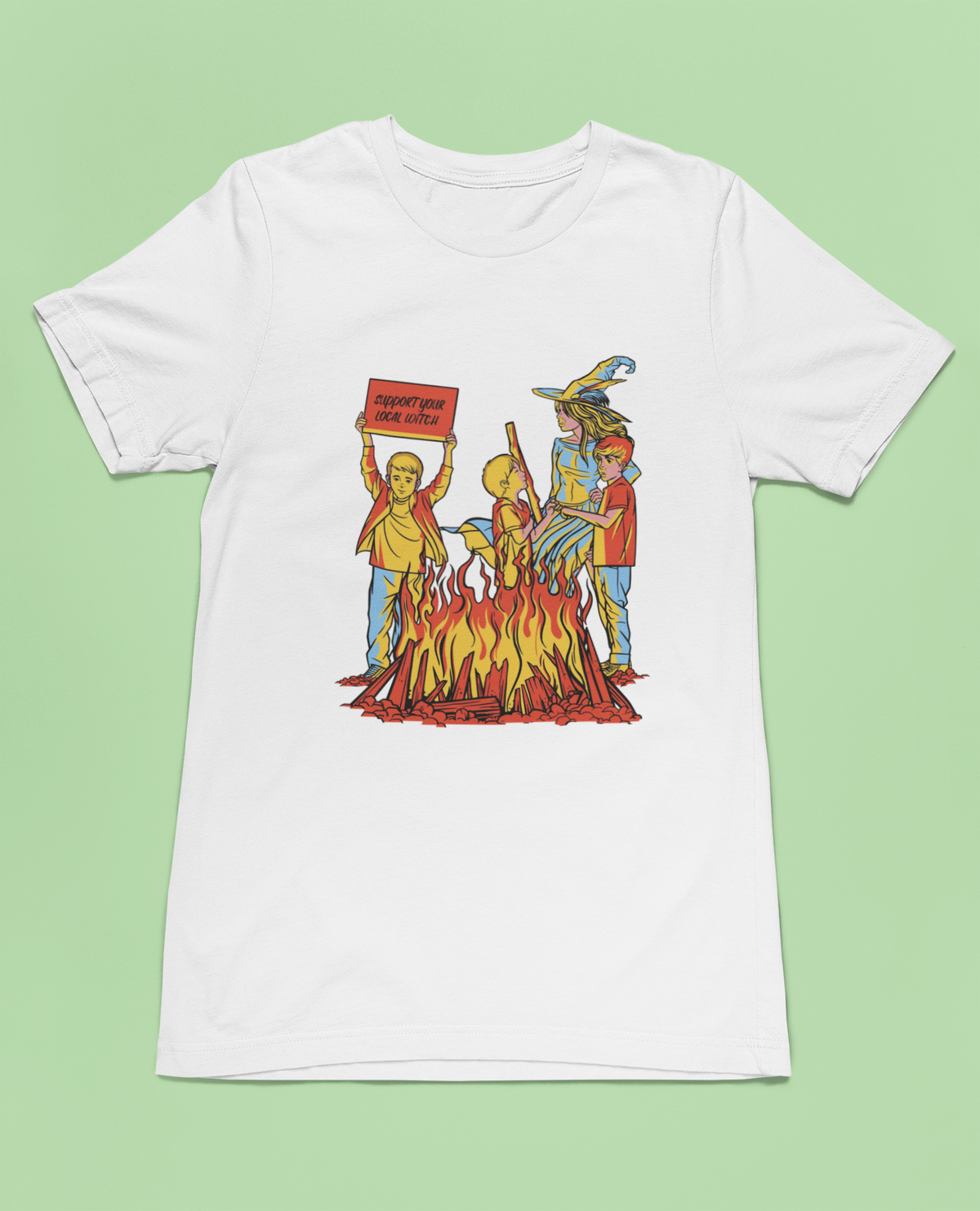 'We Love Witches' t-shirt in white, flat lay on green background