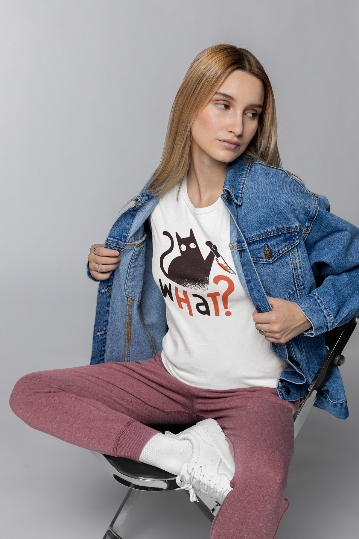 'What?' knife cat t-shirt in white, woman in denim jacket wearing it, funny dark humor gift