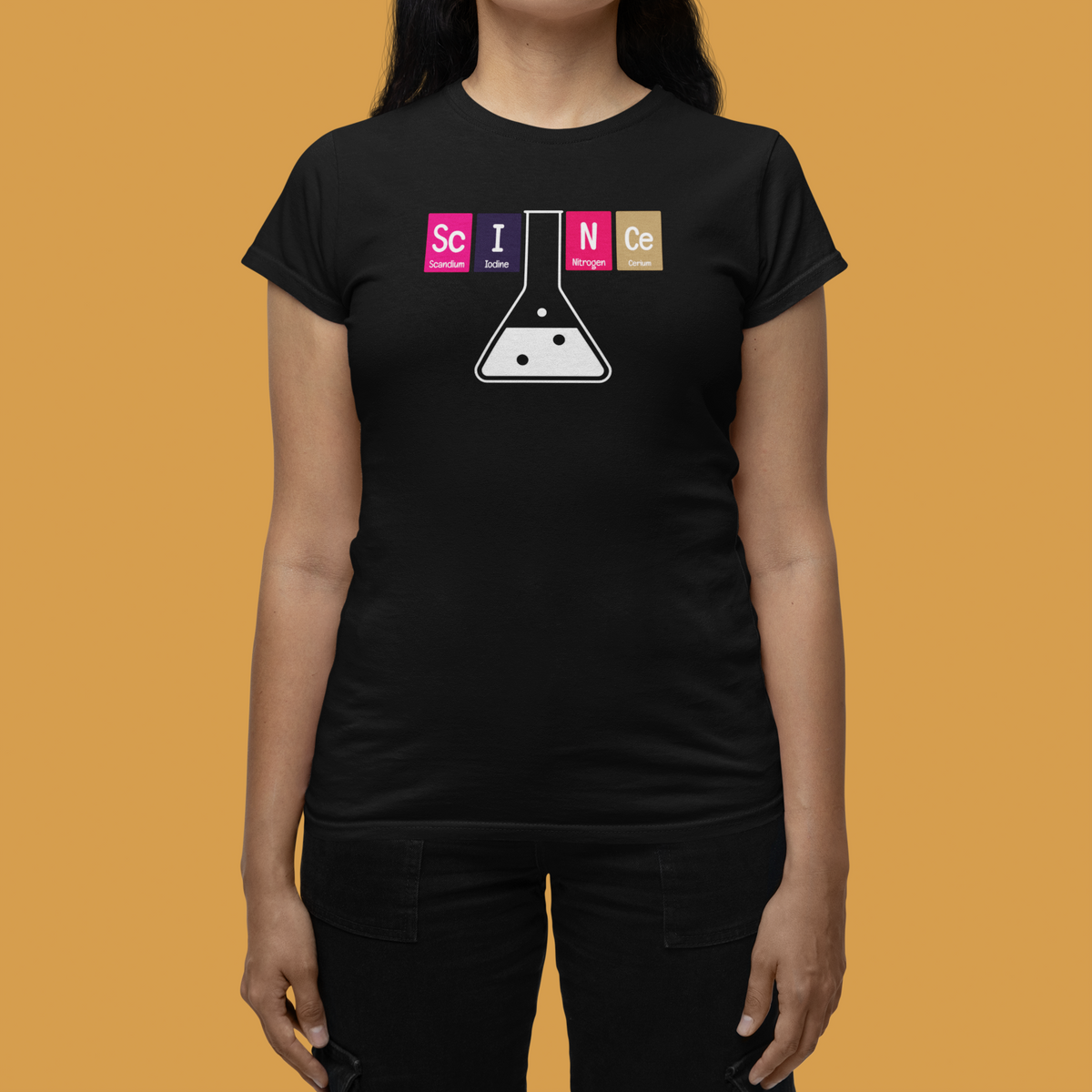 'Science' periodic table women's t-shirt in black, close-up on model, orange backdrop, funny chemistry gift
