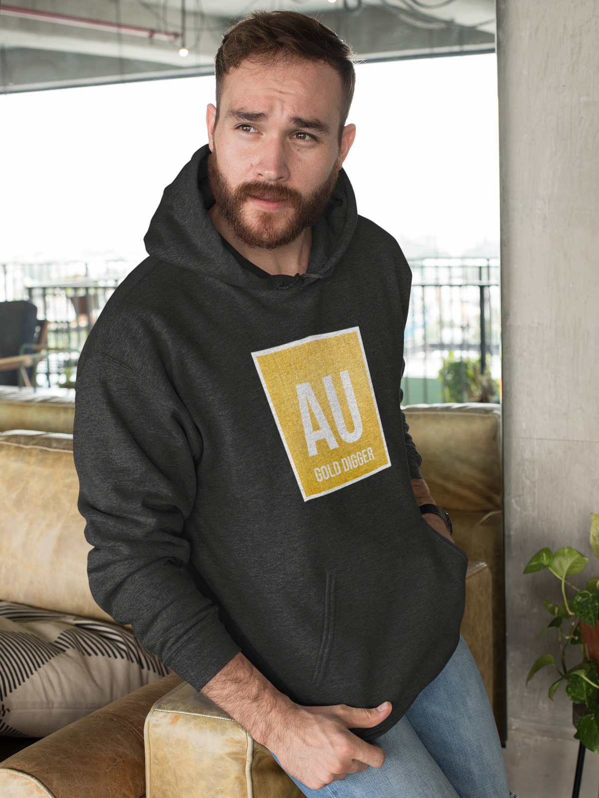 'AU Gold Digger' hoodie in charcoal grey, man sitting on couch wearing it, funny chemistry teacher gift