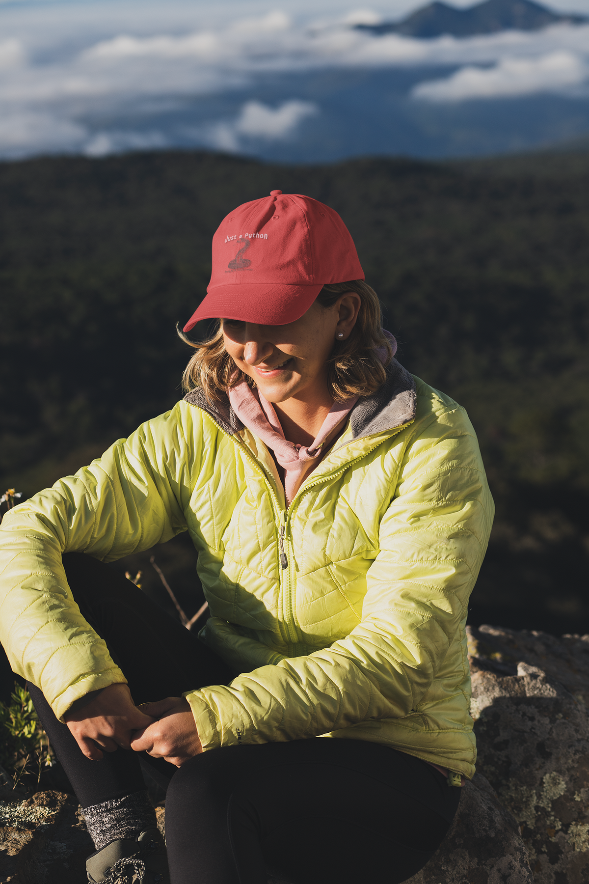 Just a Python embroidered dad hat worn by a woman on a mountain hike, lifestyle mockup, Geekpsters
