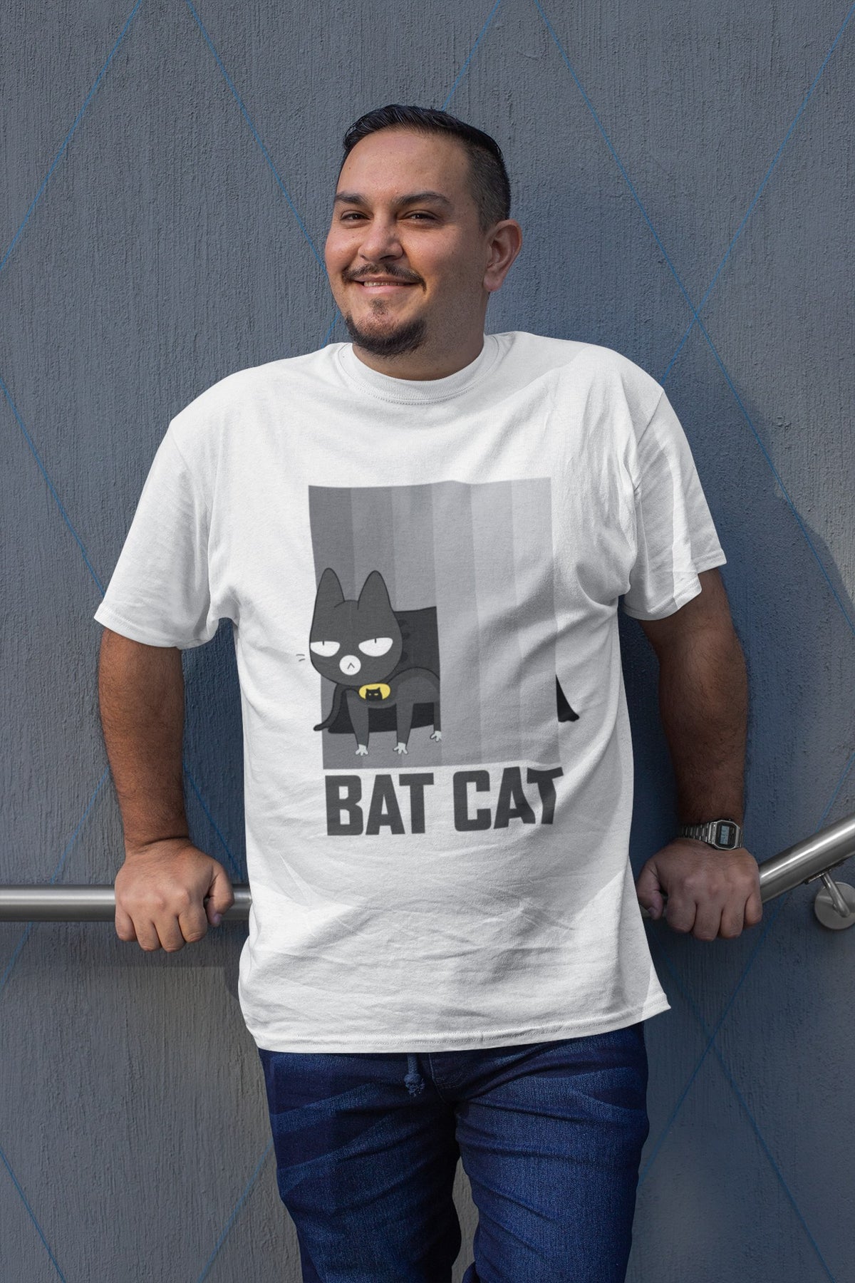 BATCAT tee in white, smiling man leaning on a wall, funny cat and superhero mashup gift