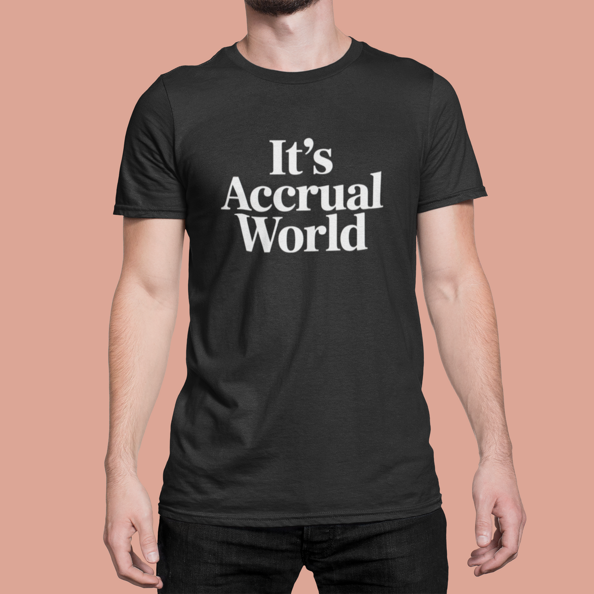 'It's Accrual World' t-shirt in black, man wearing it full front view on coral background, accountant gift