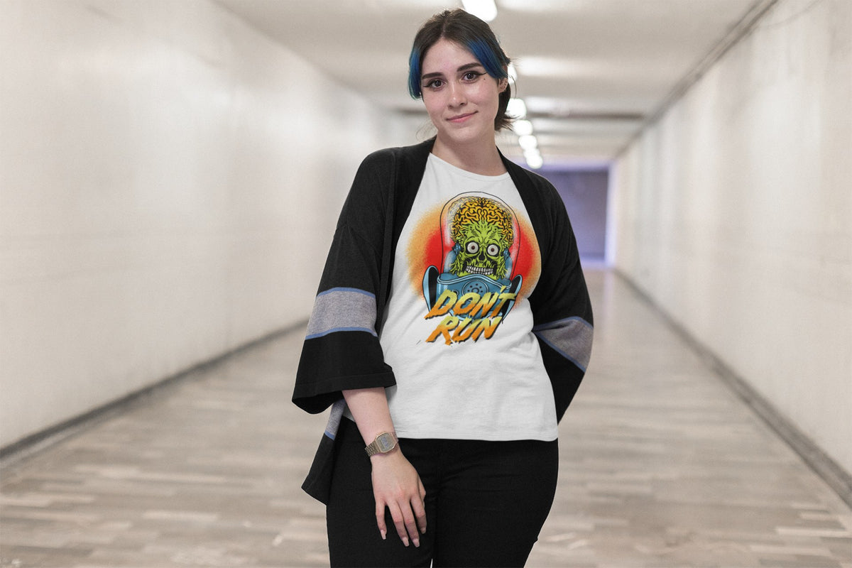 Don't Run alien graphic women's tee in black, woman wearing it in a studio, horror and sci-fi fan tee for women