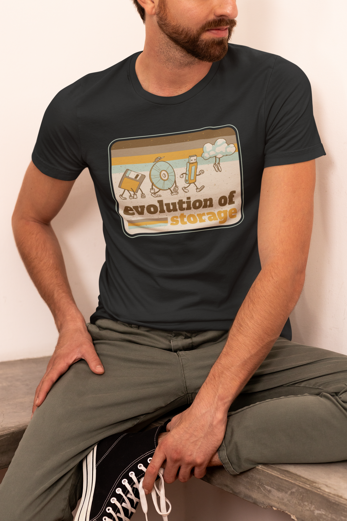 'Evolution of Storage' t-shirt in black, man model seated wearing it, funny retro computer gift shirt