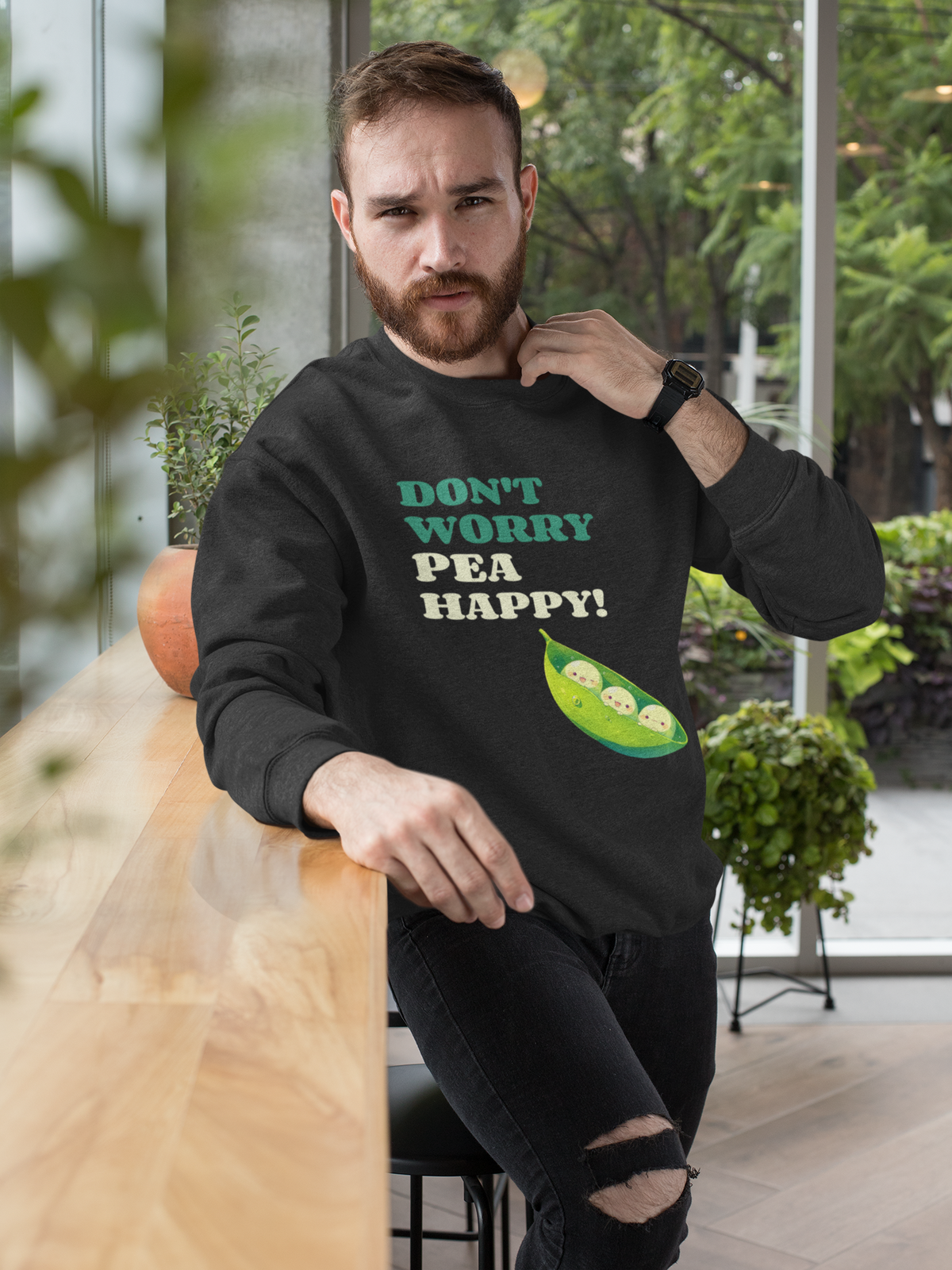 'Don't Worry Pea Happy' pea pun sweatshirt in black, bearded man wearing it outdoors, funny gift
