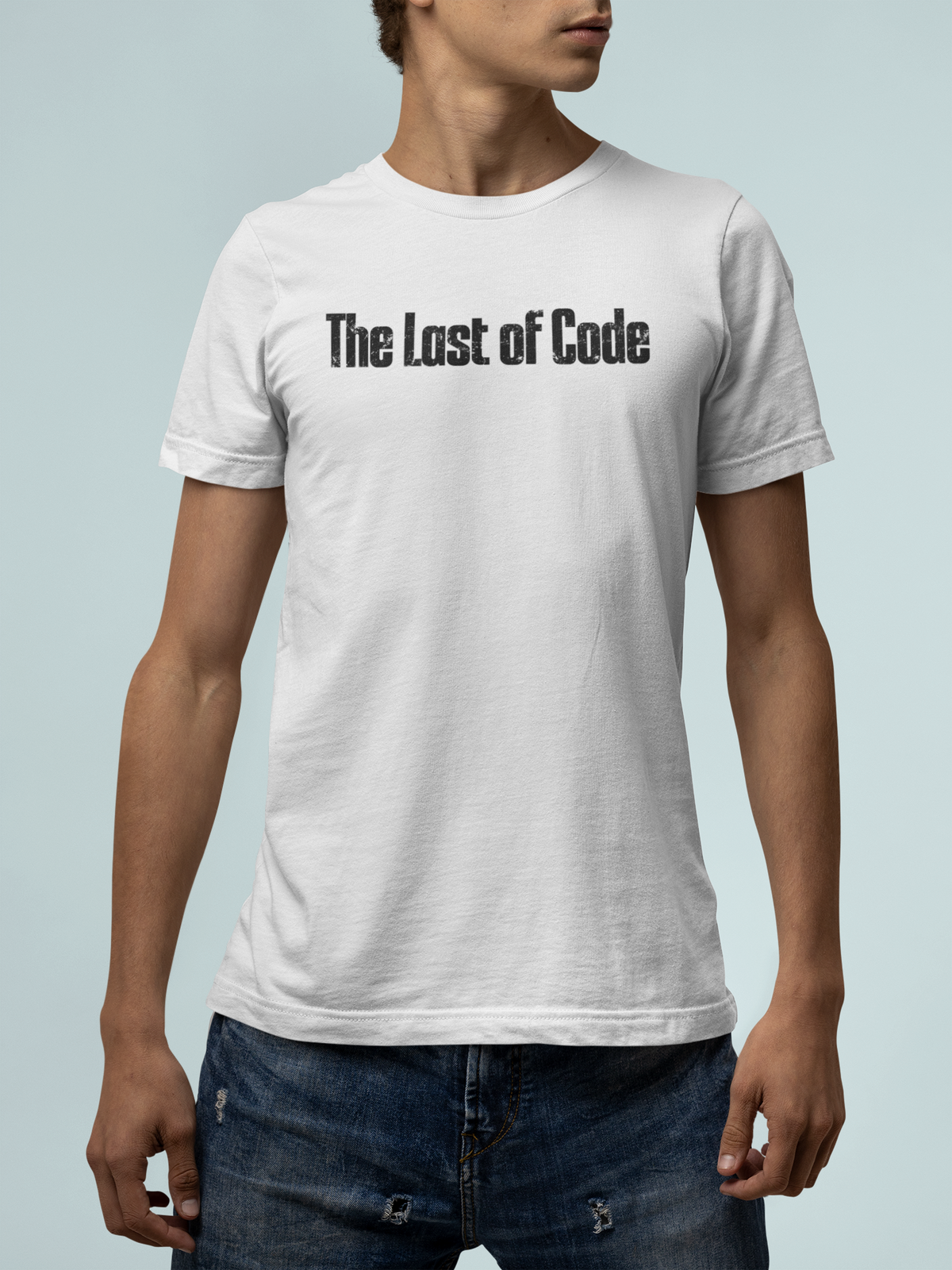 'The Last of Code' T-shirt in white, man wearing it against a light blue backdrop, funny gamer tee