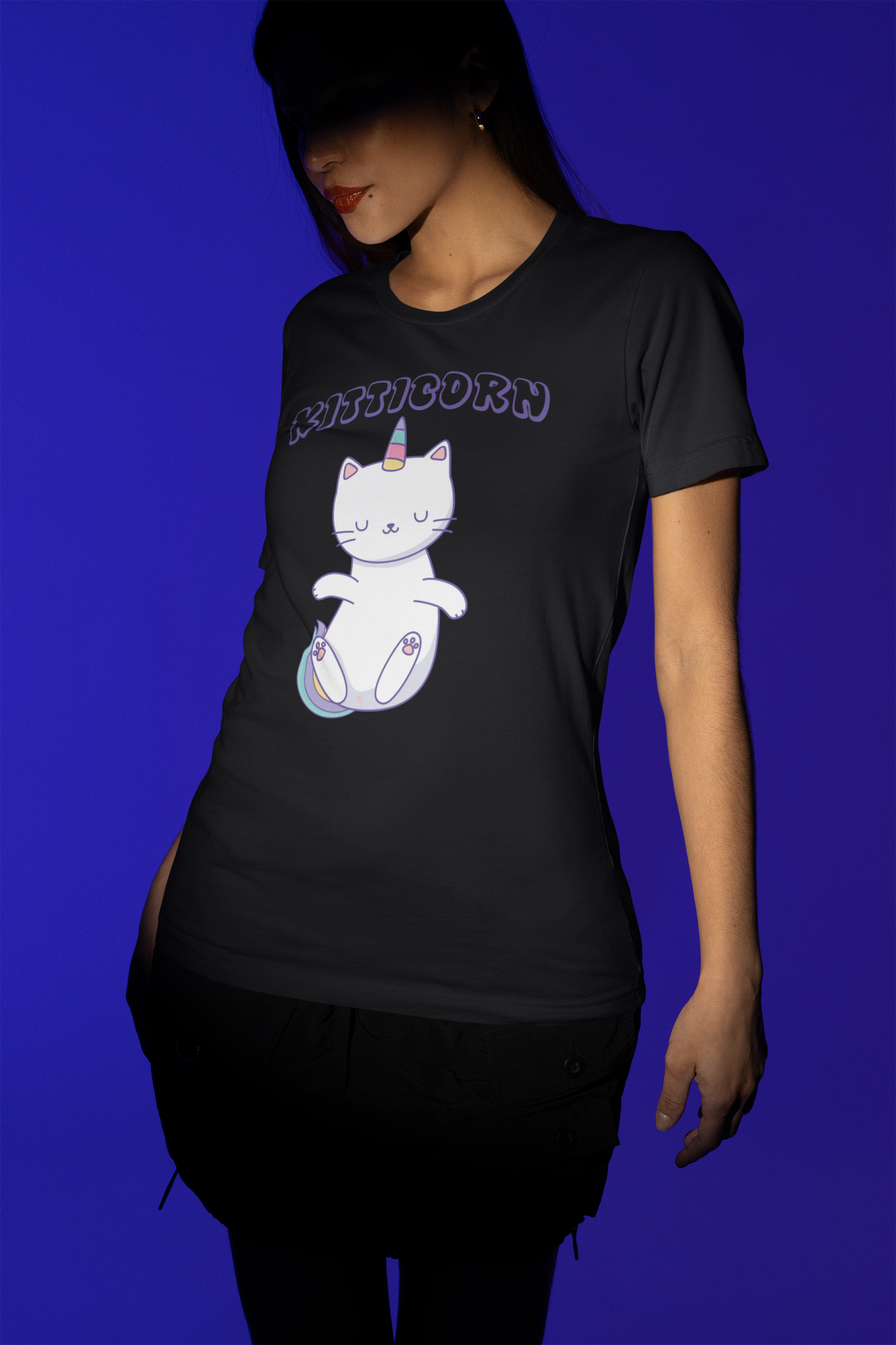 'Kitticorn' cat unicorn mashup T-shirt in black, woman wearing it against a blue backdrop, gift tee