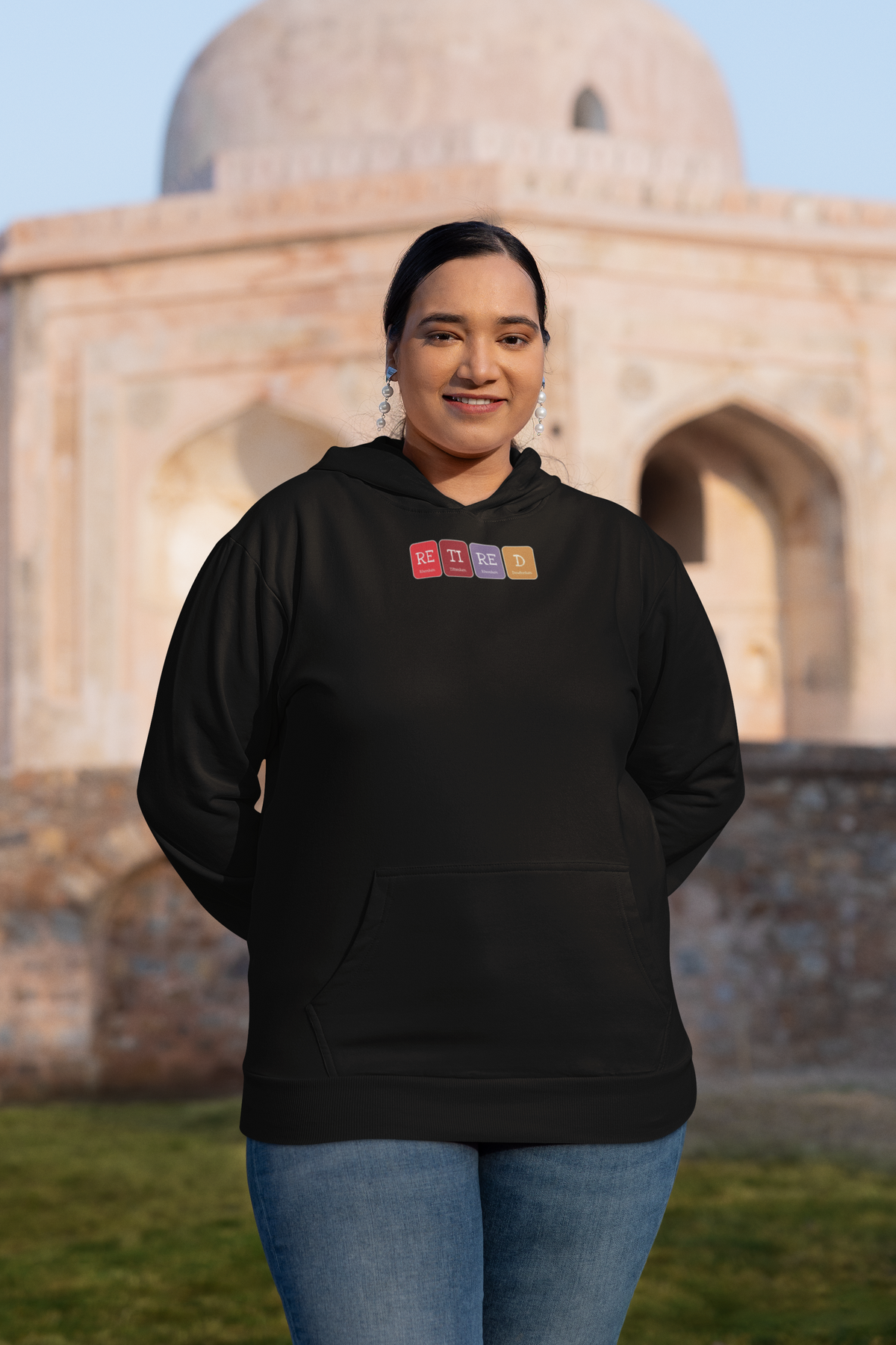 'Retired Periodic Table Hoodie' in black, woman at a historic monument, Hoodie mockup, Geekpsters