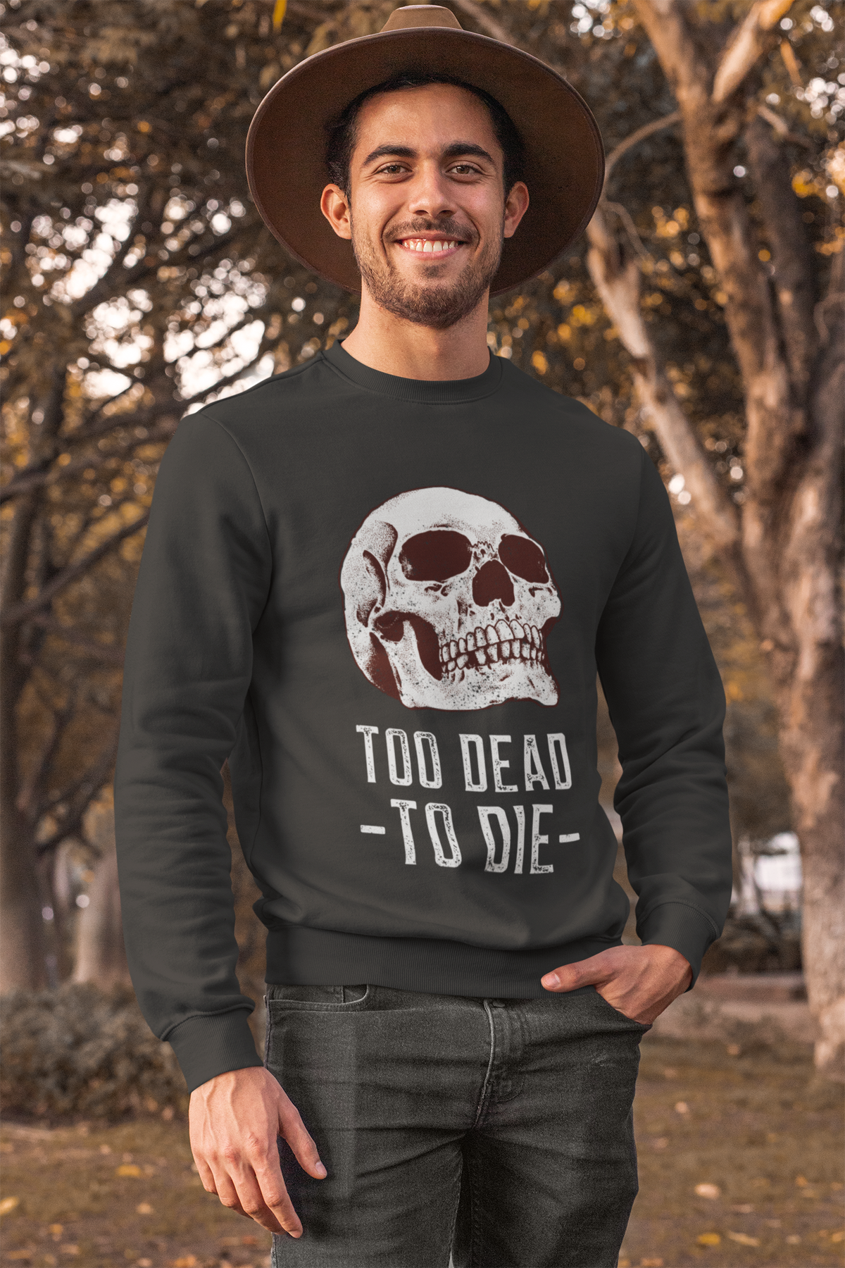 'Too Dead To Die' skull graphic sweatshirt in black, man wearing it outdoors in a hat, funny gothic gift