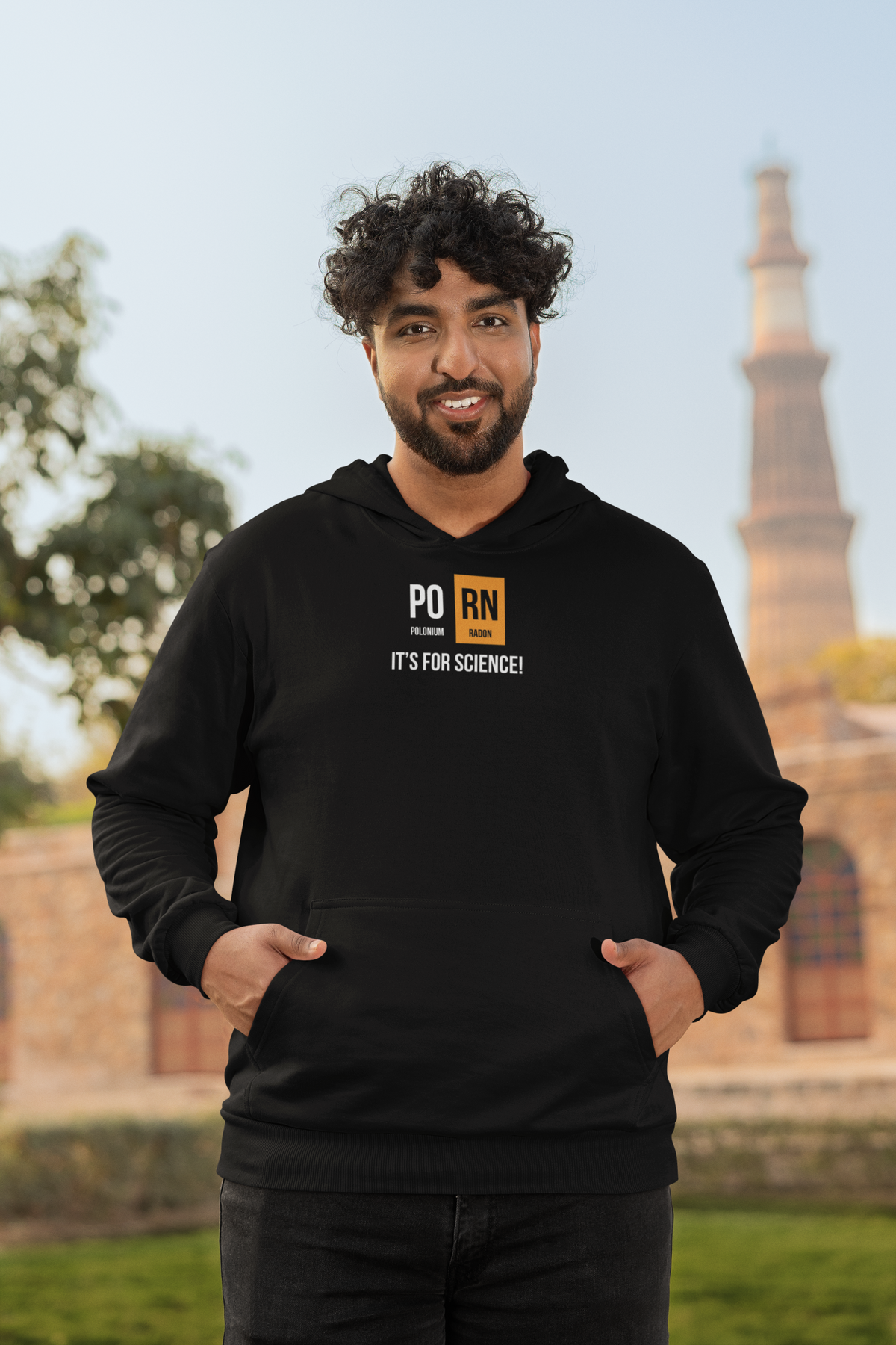 'PO-RN Periodic Table Hoodie' in black, man by a historic building, Hoodie mockup, Geekpsters
