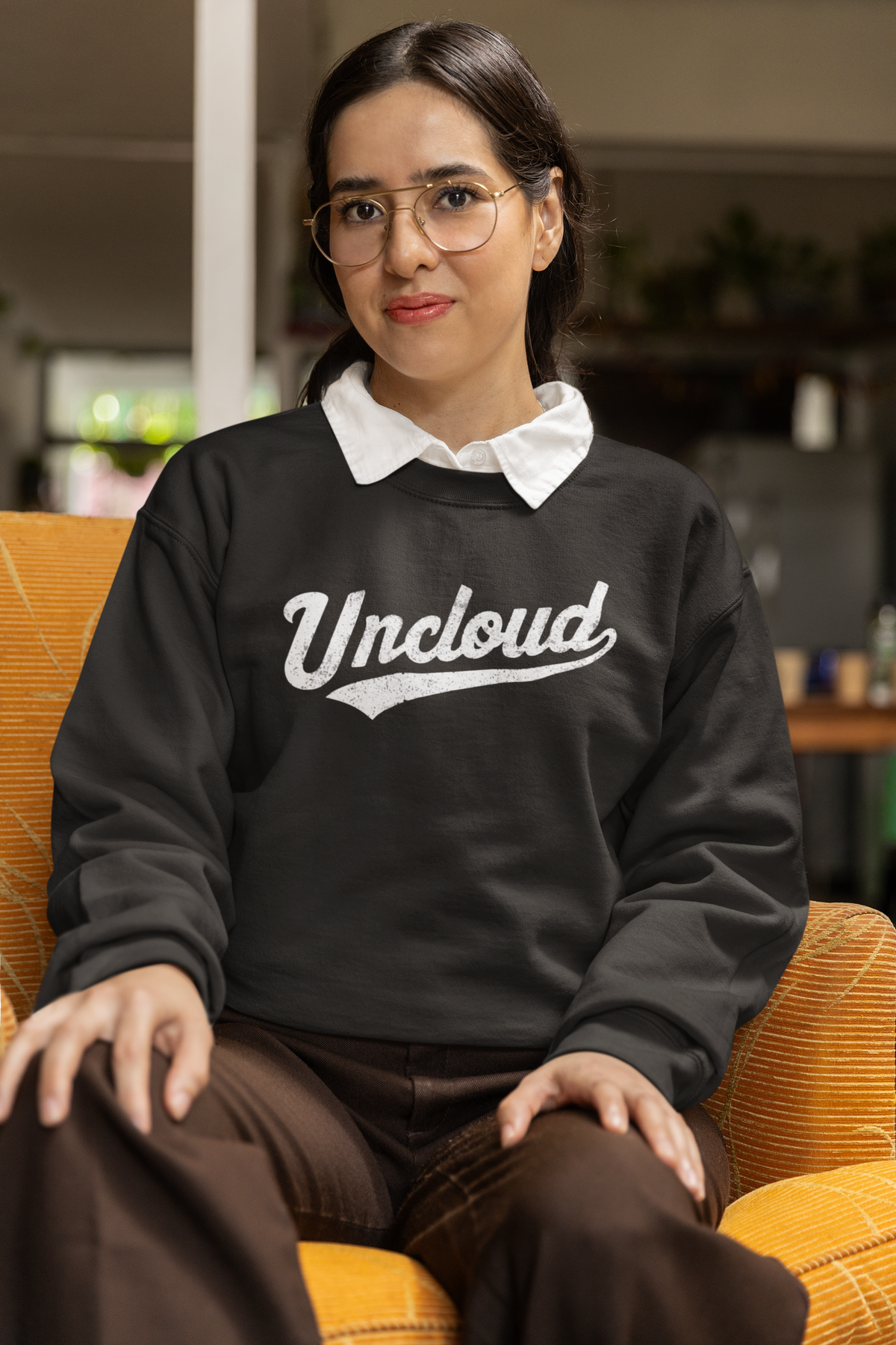 Uncloud script logo sweatshirt in black, woman wearing it seated indoors, funny coder pun gift