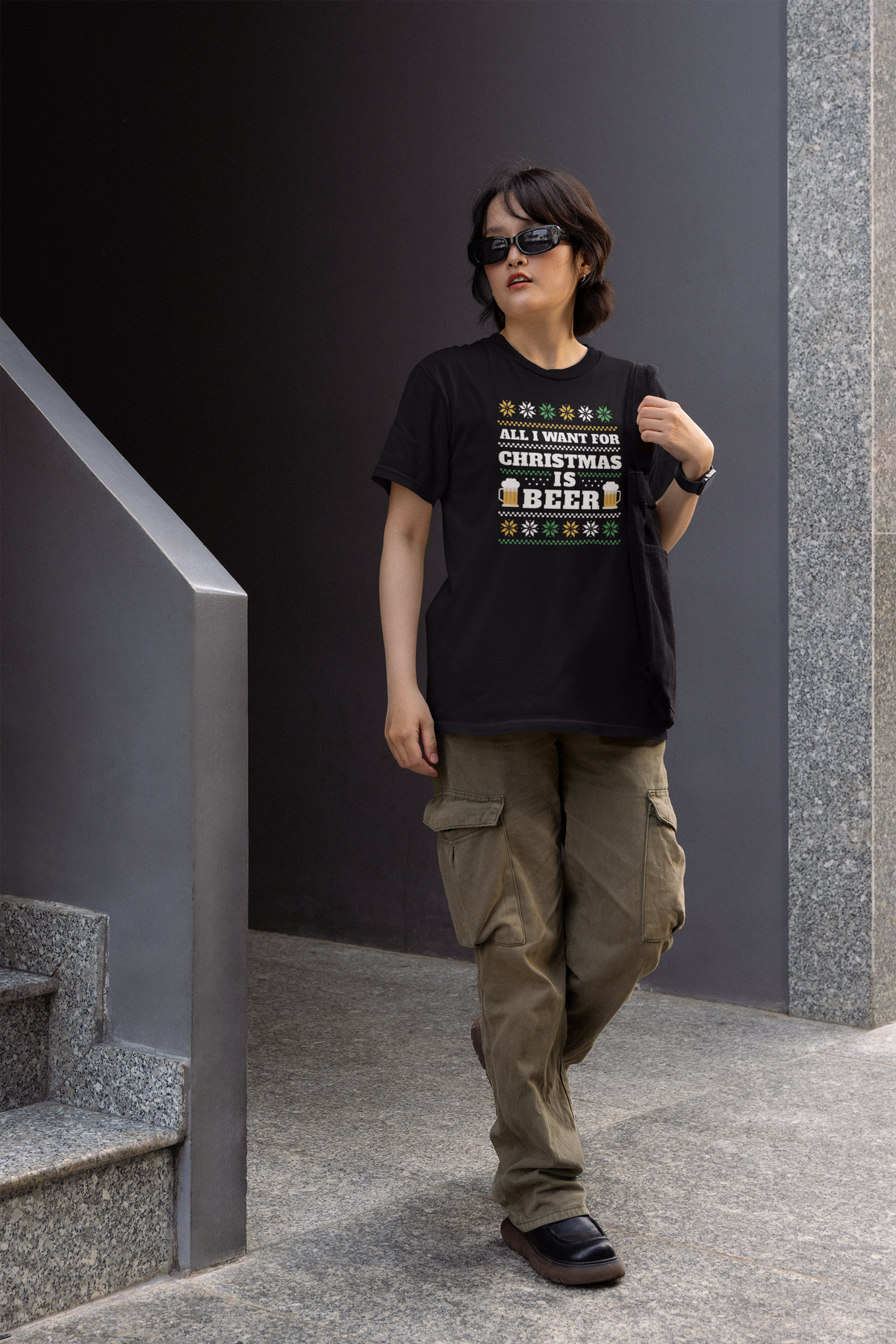 'All I Want For Christmas Is Beer' t-shirt in black, man wearing it outdoors on city stairs, funny gift