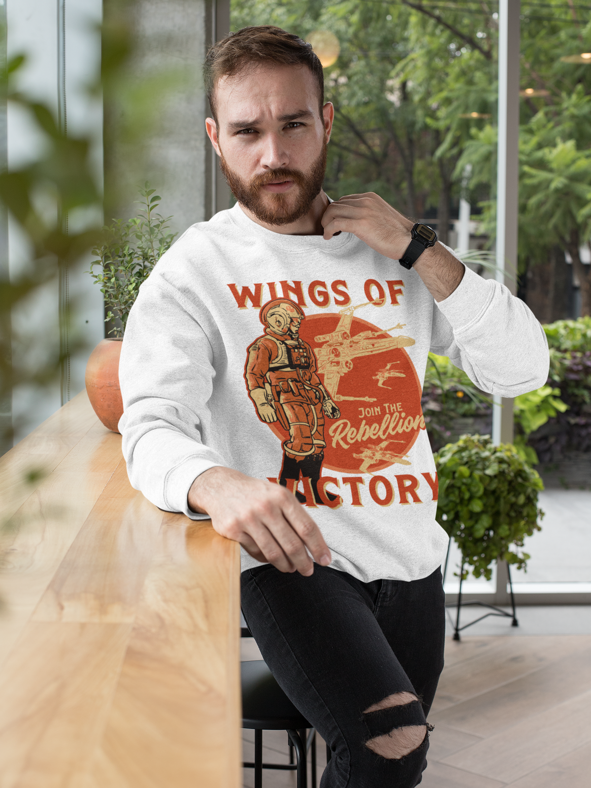 'Wings of Victory' sweatshirt in white, man wearing it indoors, warrior graphic crewneck gift for him