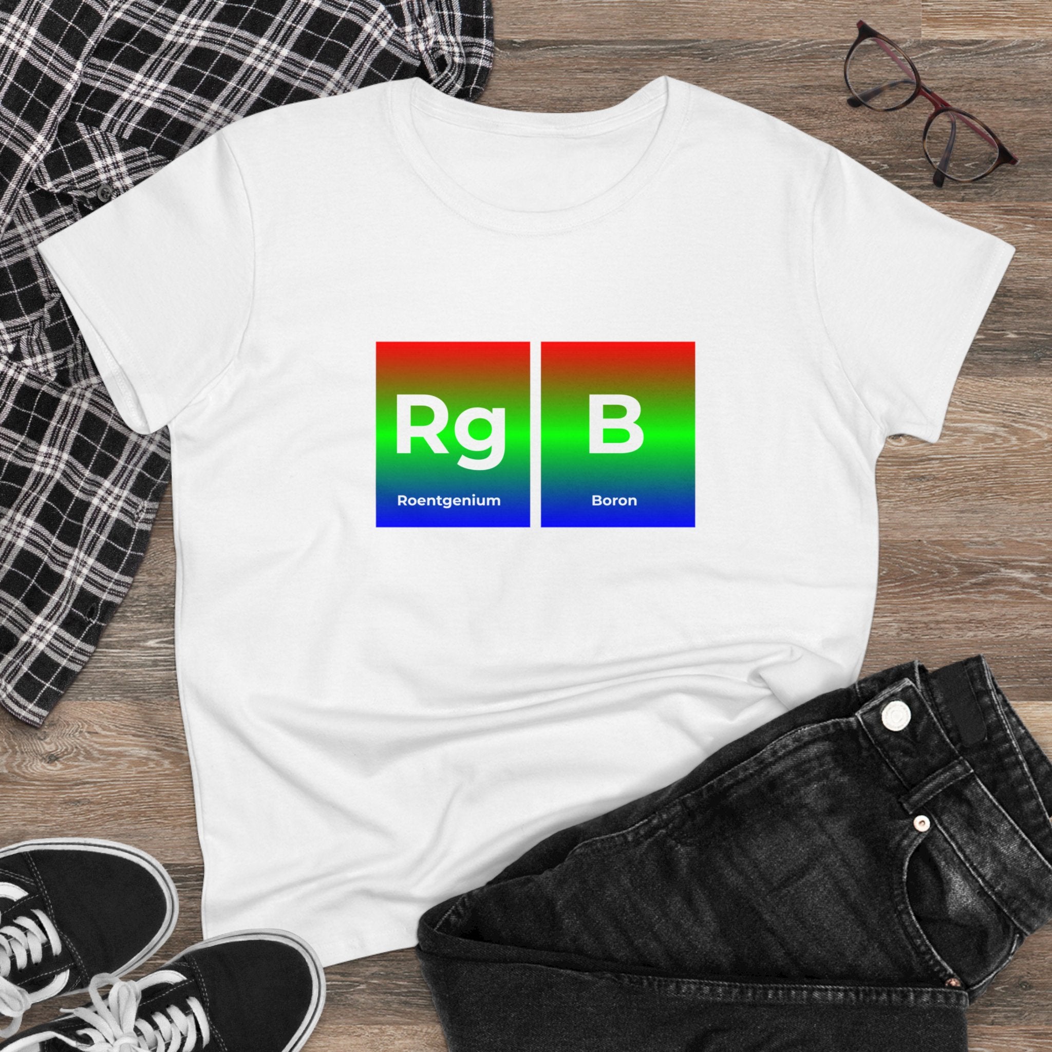 A white cotton RG-B - Women's Tee with a design featuring the elements Roentgenium (Rg) and Boron (B) on a wooden surface, paired with a black plaid shirt, black jeans, glasses, and black sneakers. Ethically fashioned for style and comfort.