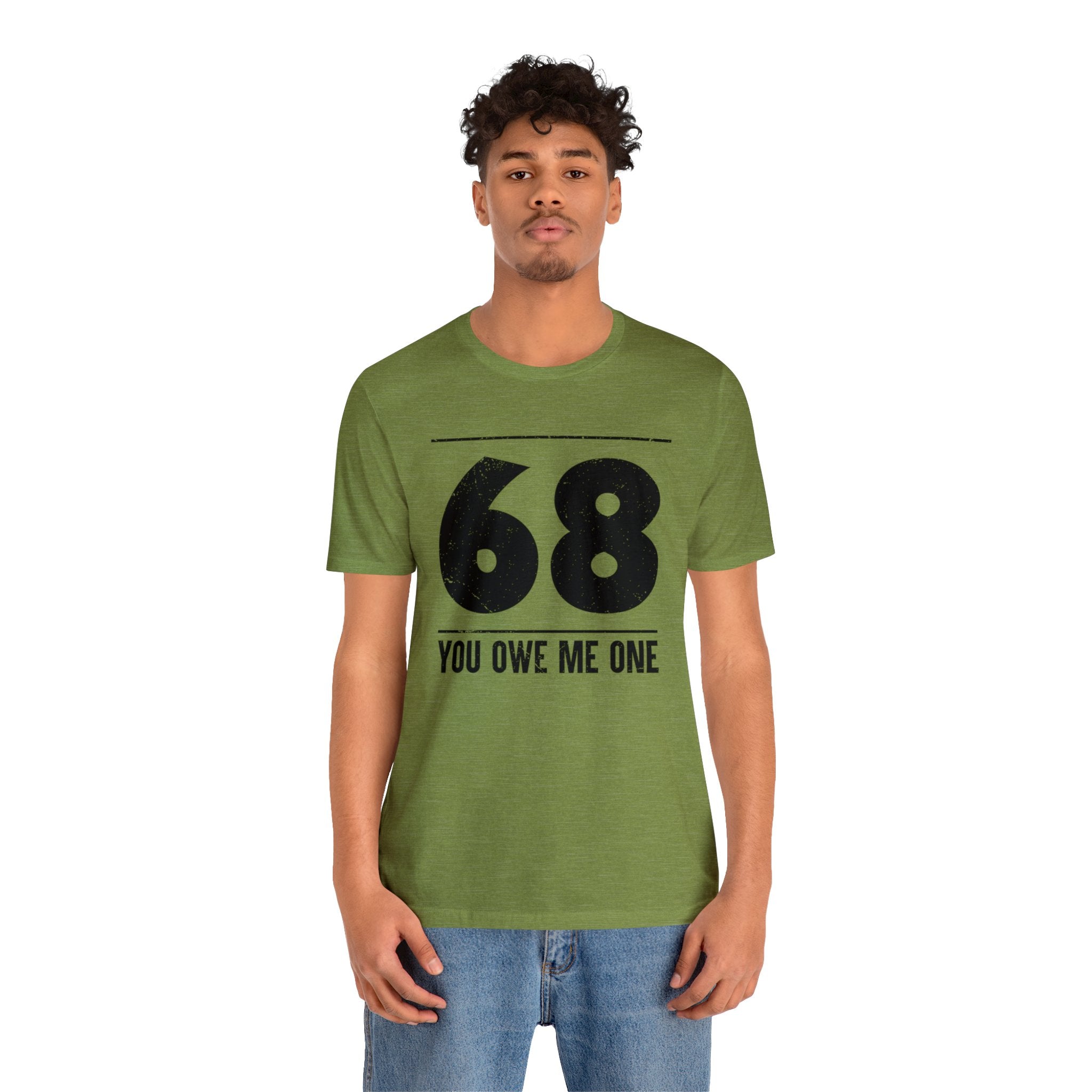 A man wearing a geeky green shirt that says '68 you owe me one'.