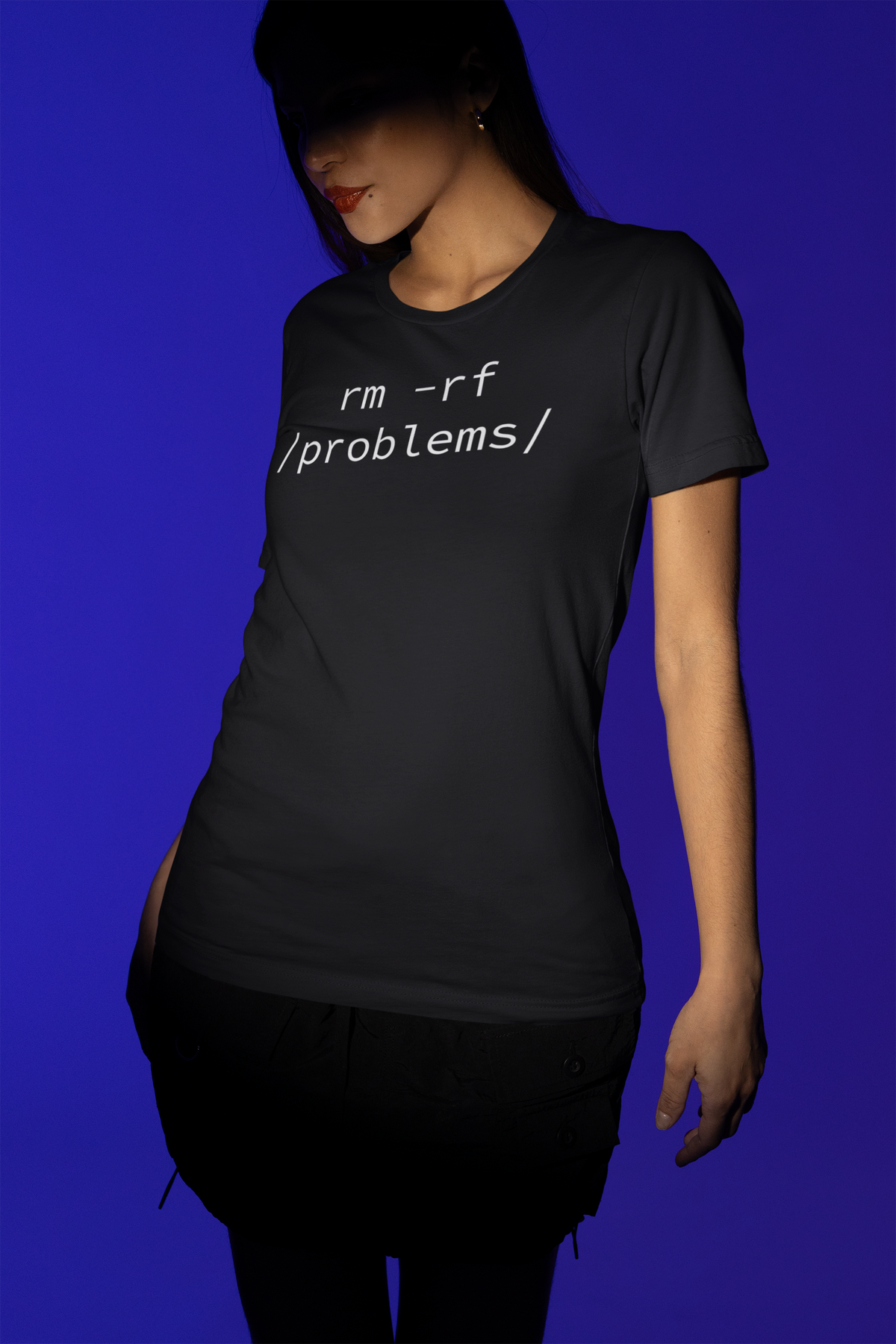 'rm -rf /problems/' t-shirt in black, woman wearing it on purple background, funny developer gift