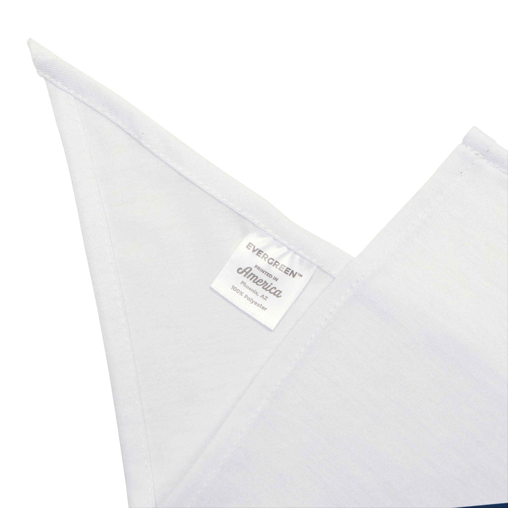 Close-up of a white fabric tag with the words "HERO - Pet Bandana, America, 100% POLYESTER" on a folded soft-spun polyester cloth.