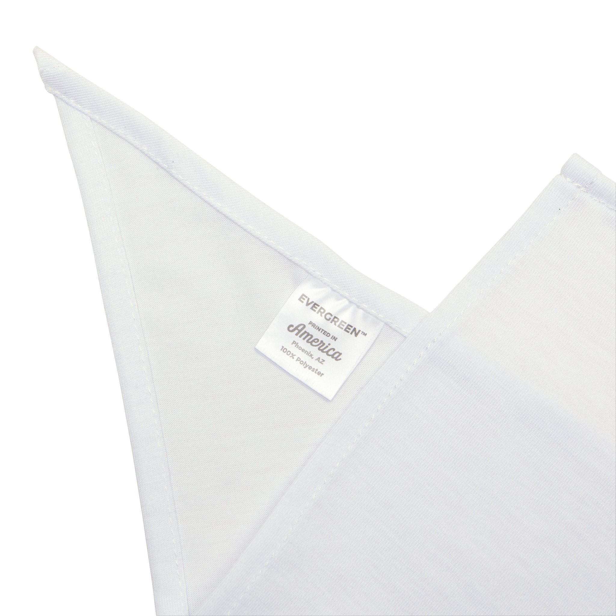 Close-up of a white fabric tag attached to a white cloth, labeled "Ge-Ni-U-S - Pet Bandana 100% polyester." The tag is visible between two white triangular folds of the cloth, ensuring irritation-free wear.