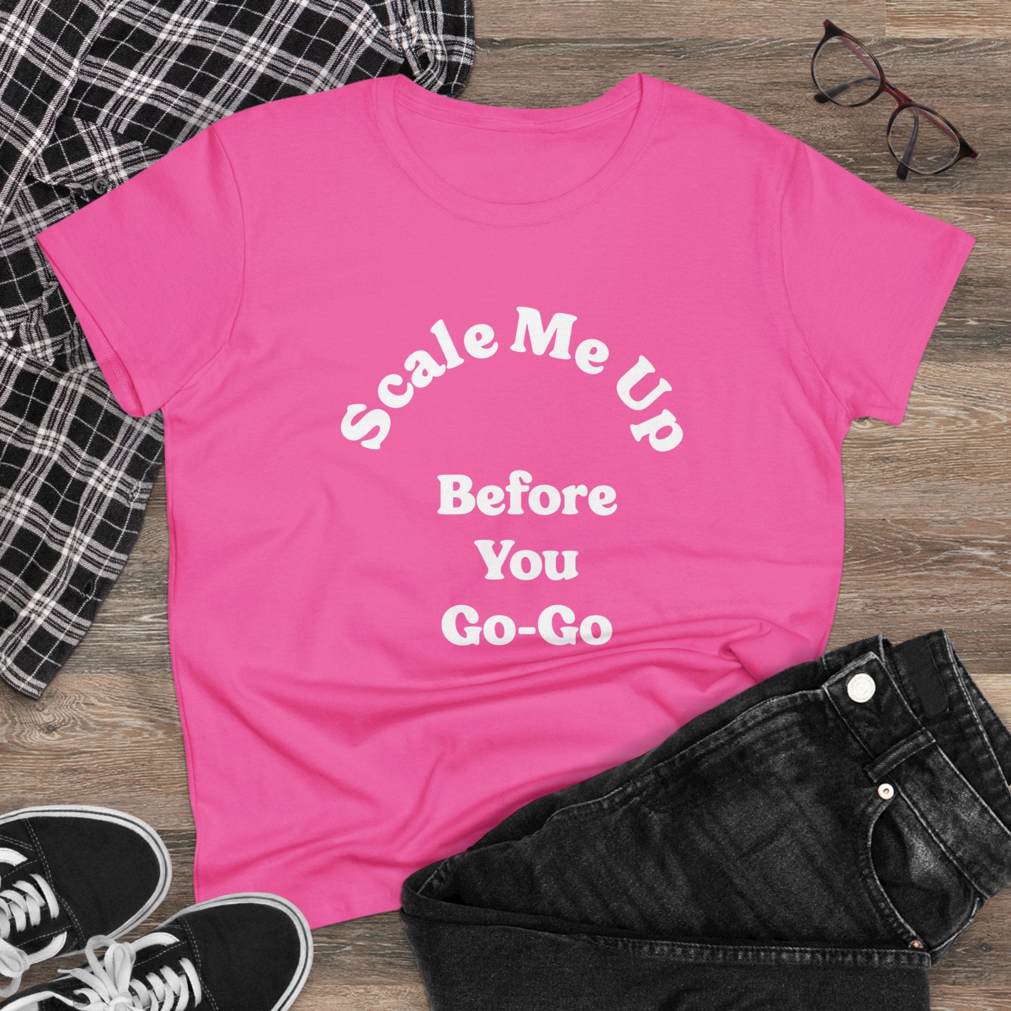 The pink "Scale Me Up Before You Go Go - Women's Tee" pairs perfectly with black jeans, a plaid shirt, and black sneakers for a wardrobe essential. Add glasses placed on a wooden surface to achieve an effortless charm.