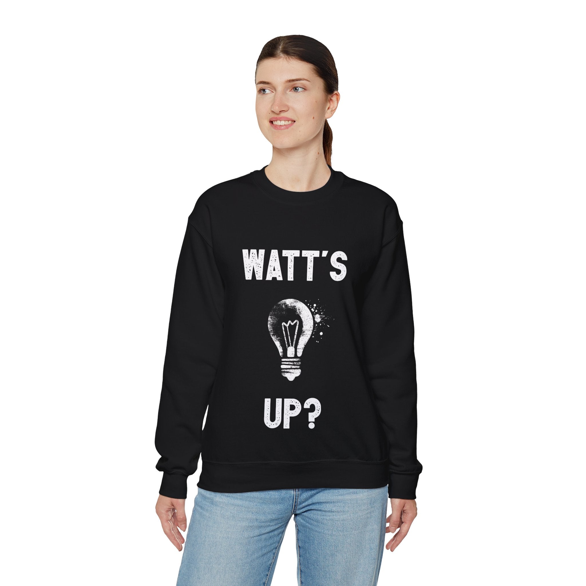 A person is wearing a trendy black "Watts Up - Sweatshirt" with the text "WATT'S UP?" and a light bulb graphic on the front, perfect to stay cozy during the colder months.