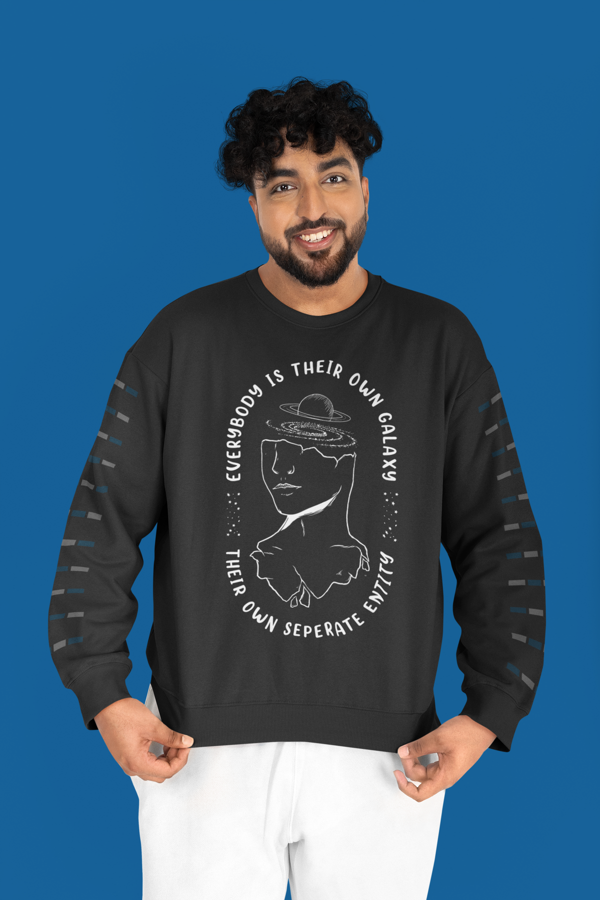 'Everybody Is Their Own Galaxy' illustrated sweatshirt in black, man standing against a blue backdrop, cozy gift