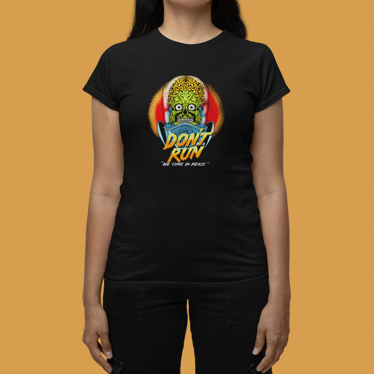 "Don't Run" zombie graphic tee in black, close-up on orange backdrop, horror fan gift for her